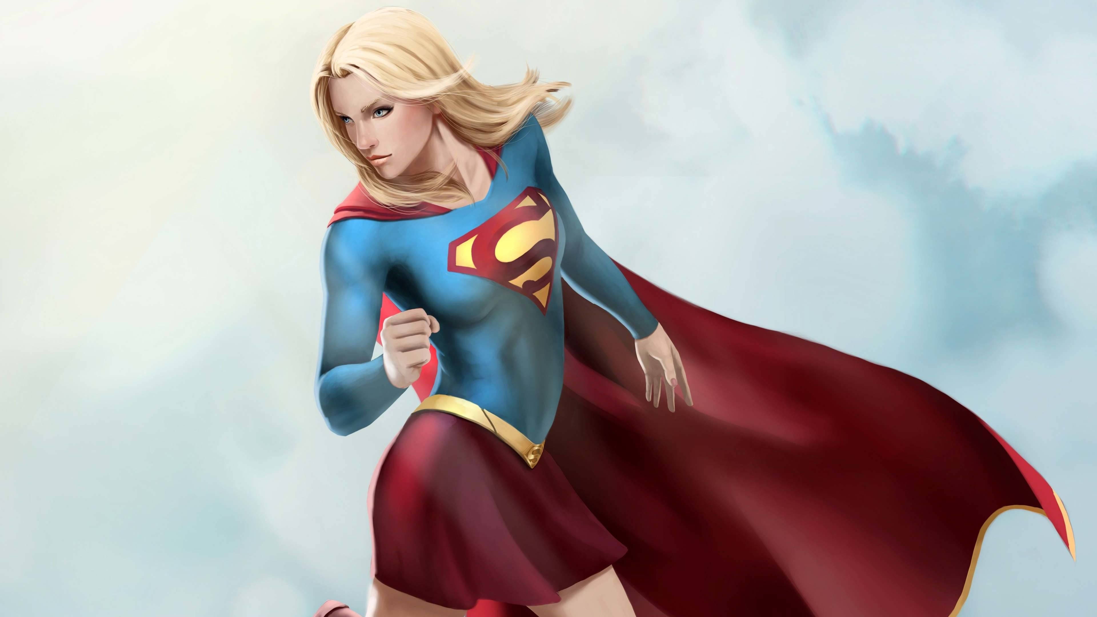 Superwoman 桌布 壁紙 — 超級女超人在柔和的多雲天空中動態奔跑，紅色斗篷在她身後飄揚。