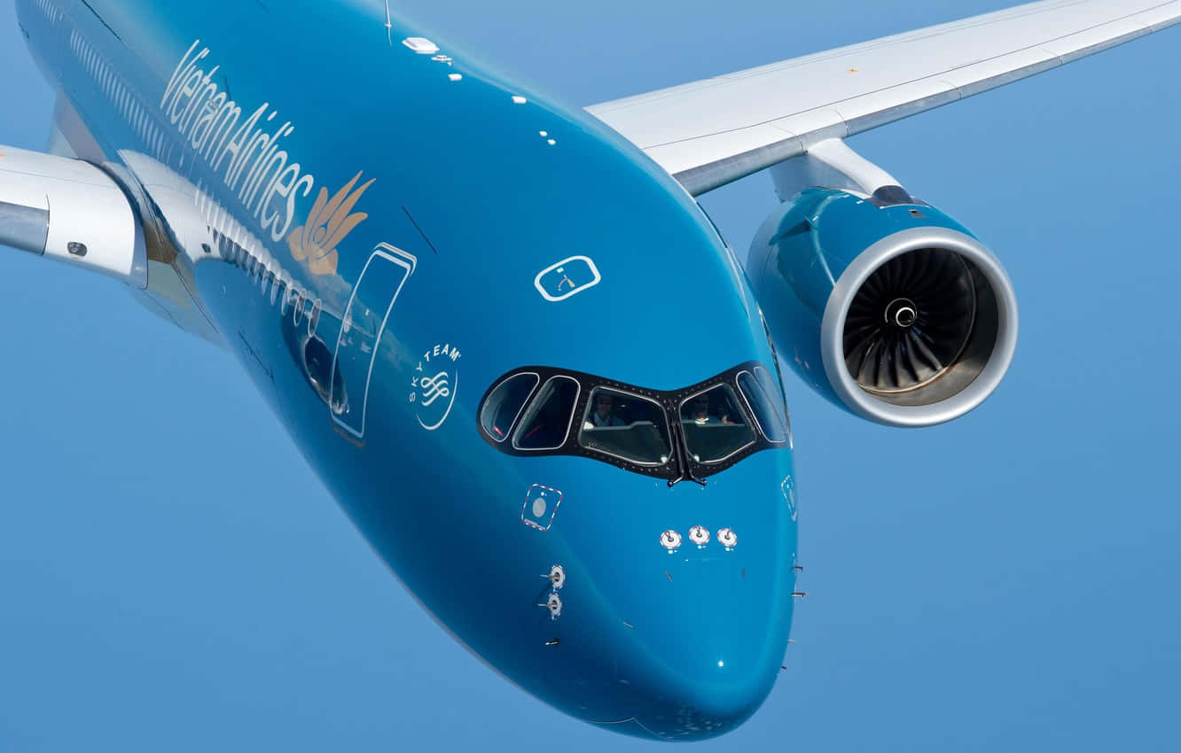 Plane 桌布 壁紙 — 越南航空飛機的藍色機身和引擎特寫，在晴朗的天空中翱翔。