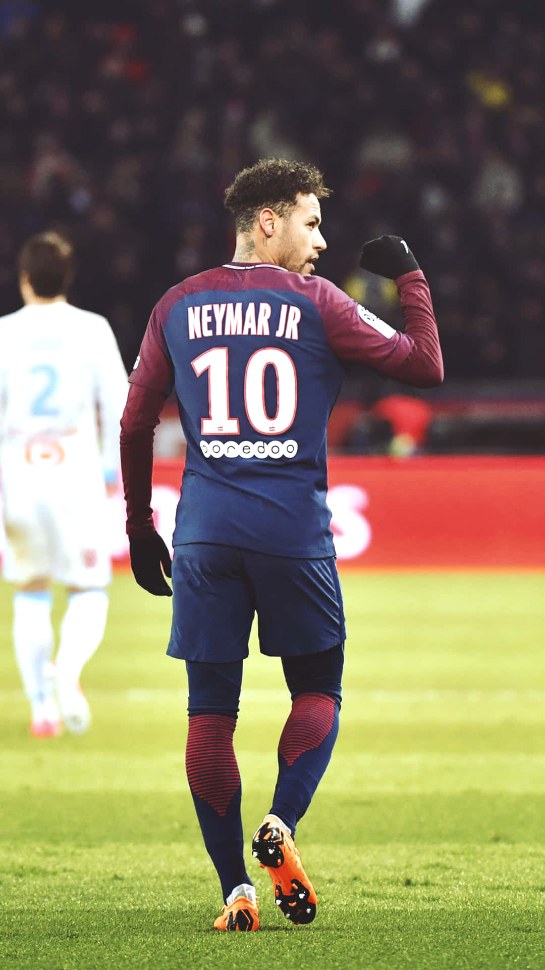 足球 桌布 壁紙 — 足球員內馬爾（Neymar Jr）身穿藍色和栗色球衣，在體育場燈光下於充滿活力的綠色球場上舉起拳頭慶祝。
