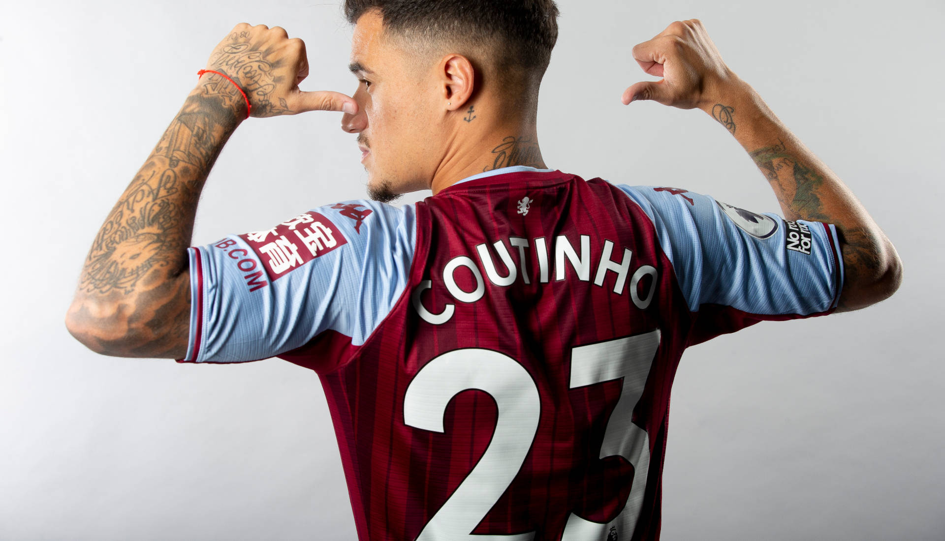 Coutinho 桌布 壁紙 — 足球員古天奴在純灰色背景前，穿著栗色和藍色球衣，彎曲手臂擺姿勢。