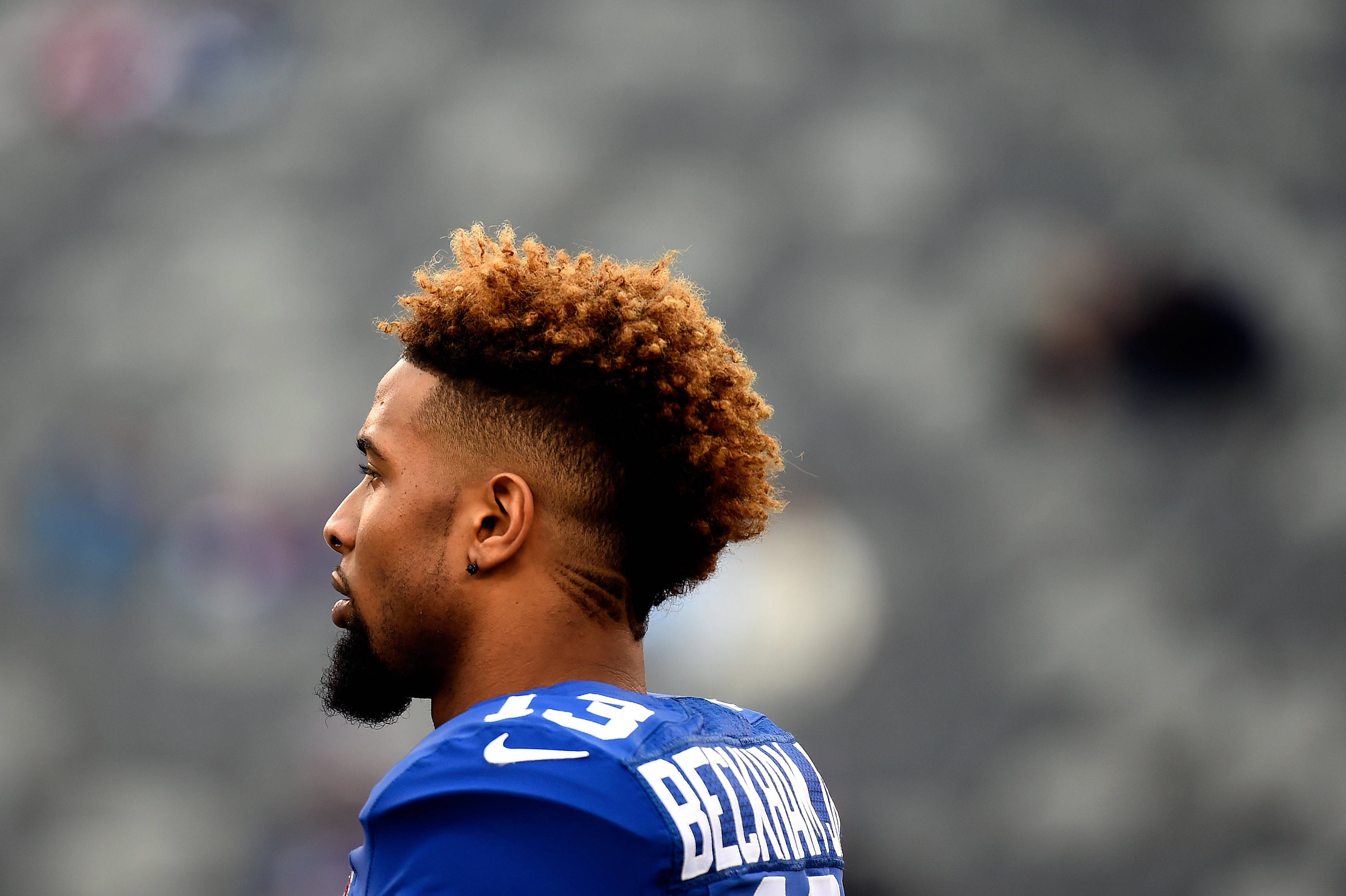 Odell 桌布 壁紙 — 足球員近距離側面照，棕色捲髮、鬍鬚，身穿13號藍色球衣。