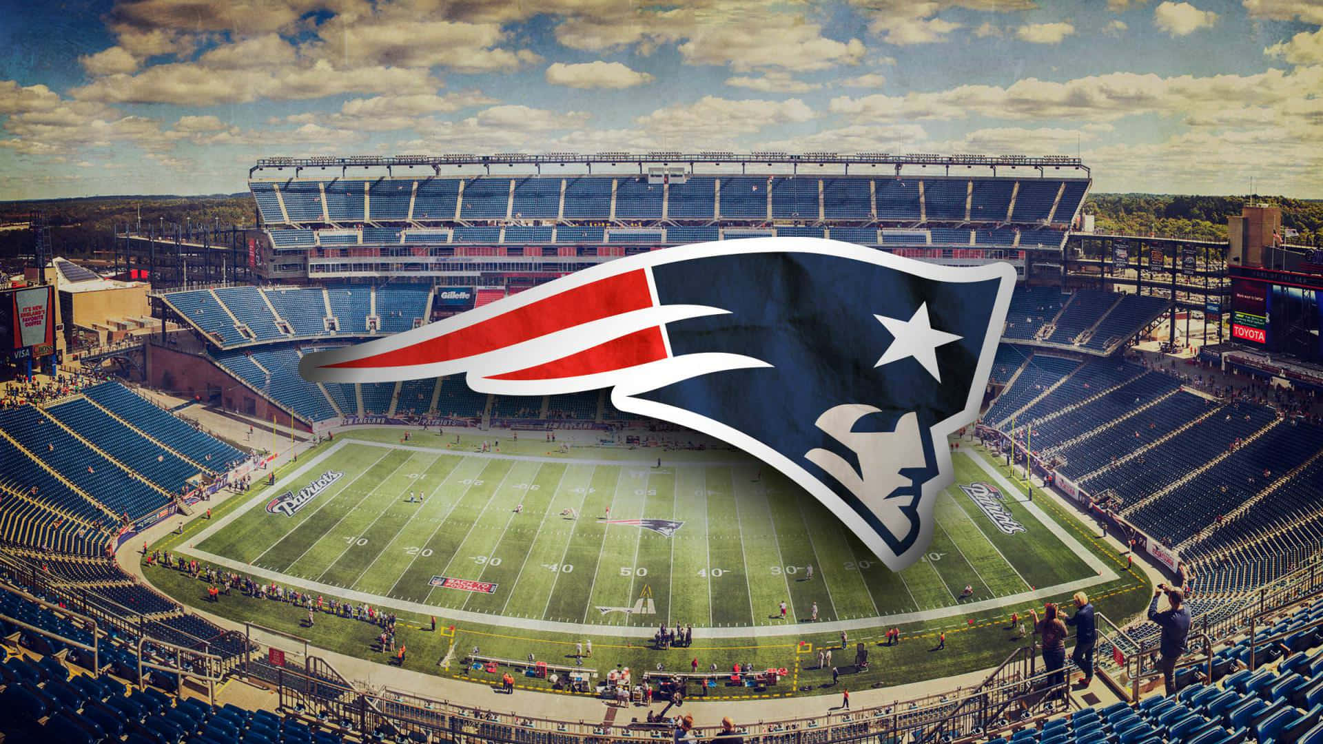 Patriots 桌布 壁紙 — 足球場的鳥瞰圖，新英格蘭愛國者隊標誌在部分多雲的天空下突出地疊加在場地上。