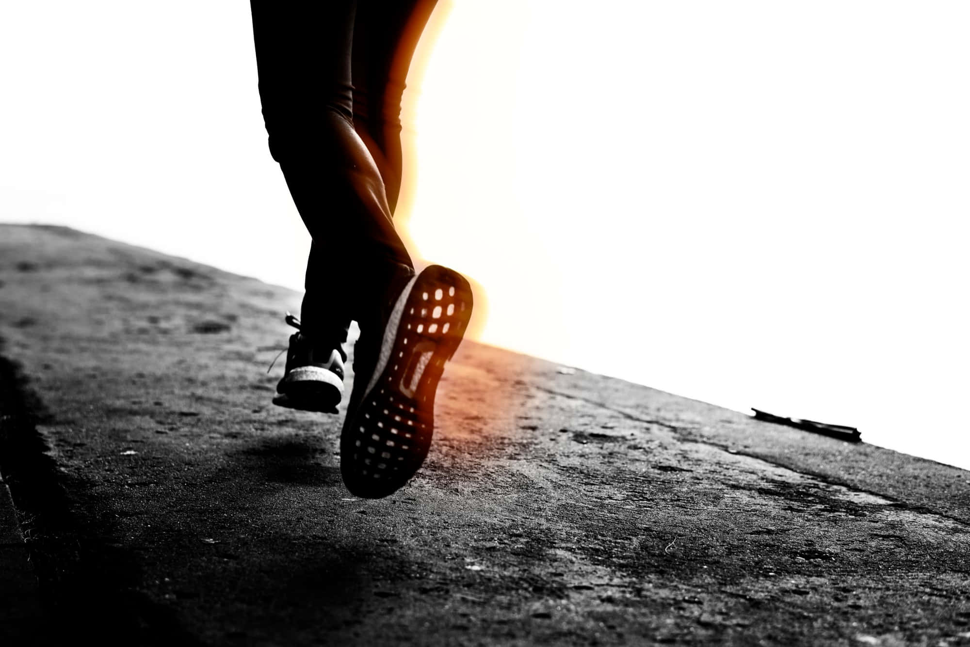 Exercise 桌布 壁紙 — 跑者的剪影在混凝土小徑上向上邁步，金色夕陽的光芒在他們抬起的腳後閃耀。