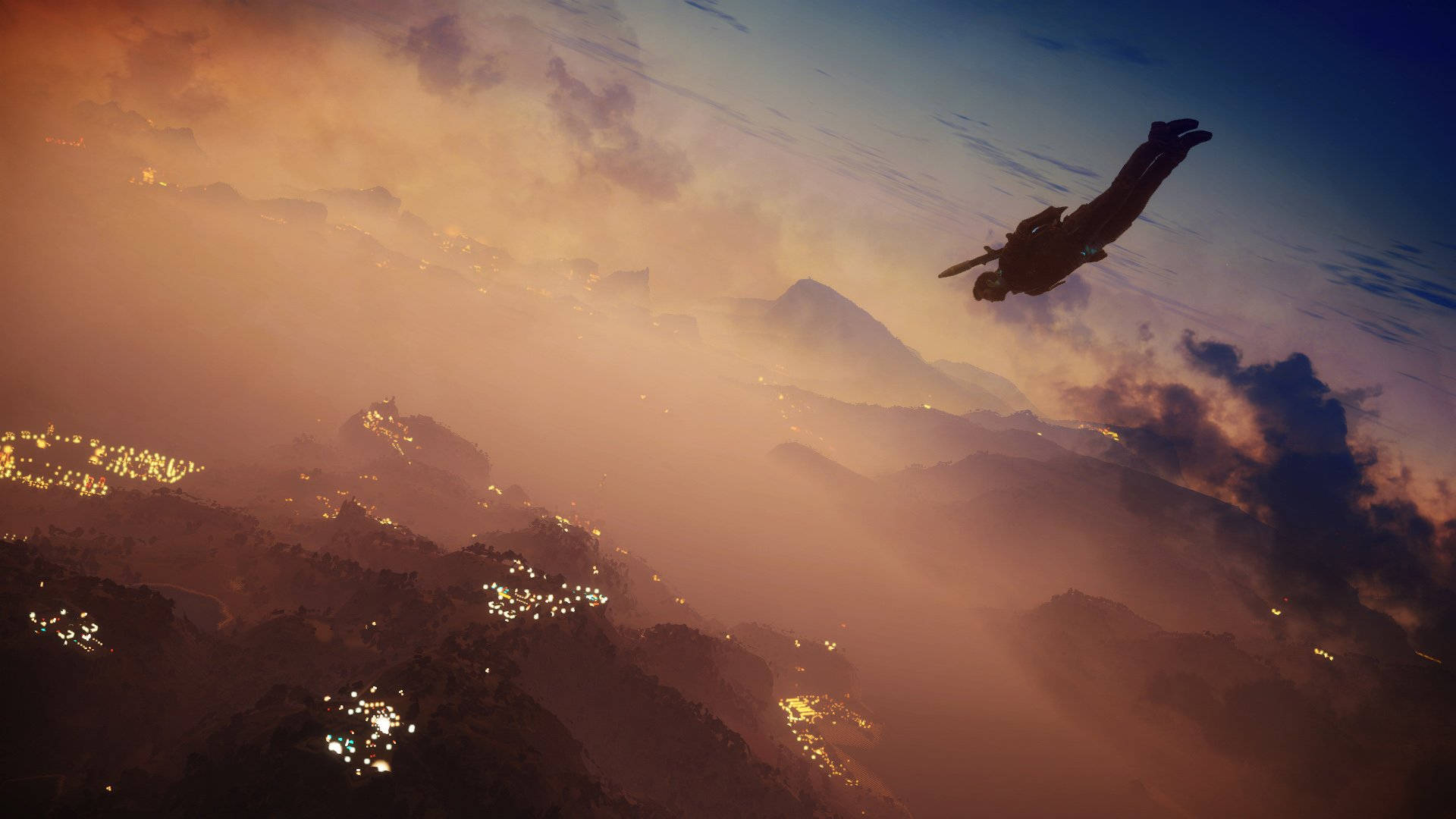 just cause 2 桌布 壁紙 — 跳傘運動員在閃爍的城市燈光點綴的山區地形上空，以發光的日落天空為背景形成剪影。