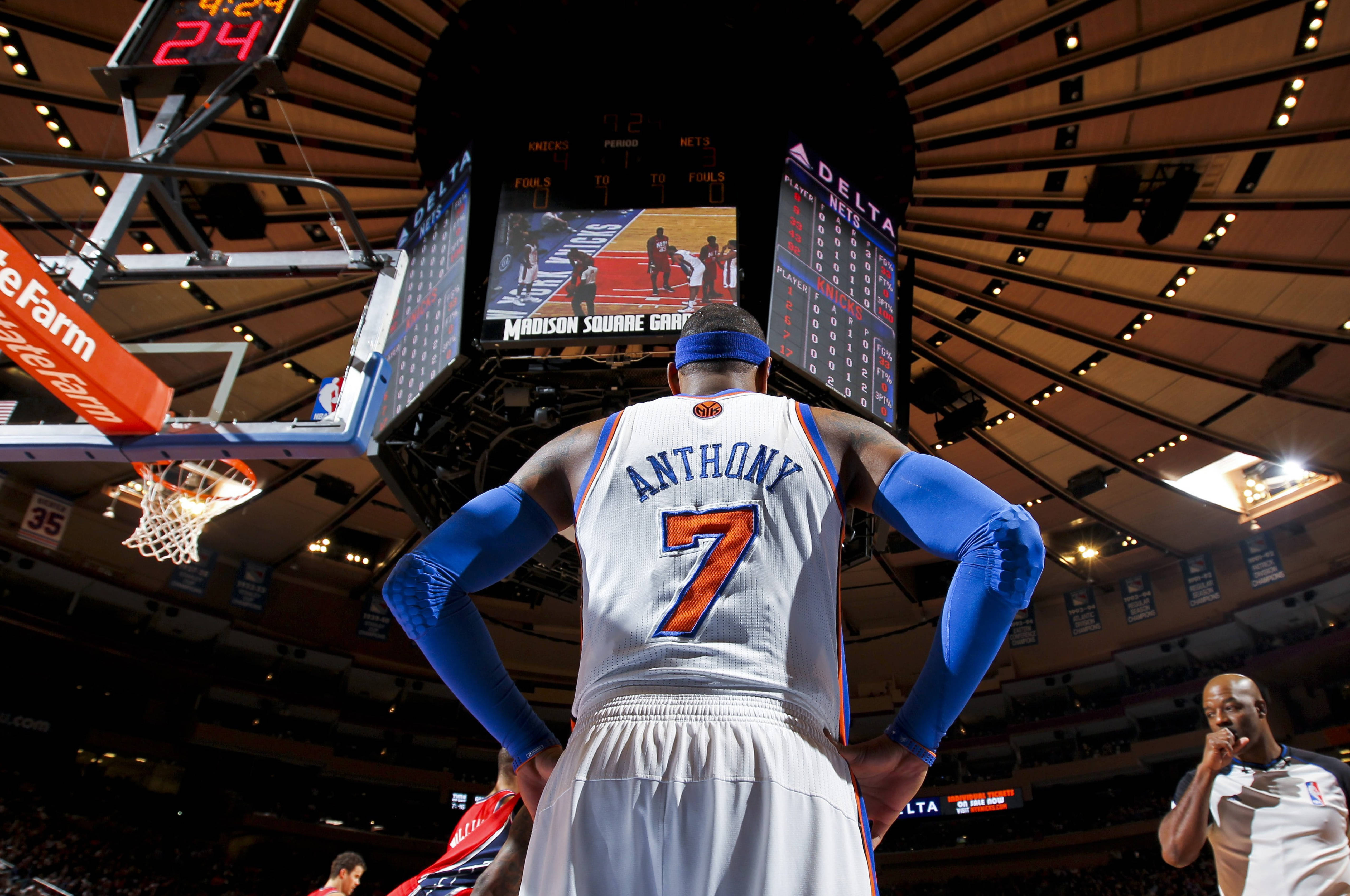 Carmelo 桌布 壁紙 — 身穿7號球衣的籃球運動員在麥迪遜廣場花園的場館燈光下，雙手叉腰，面向記分板站立。