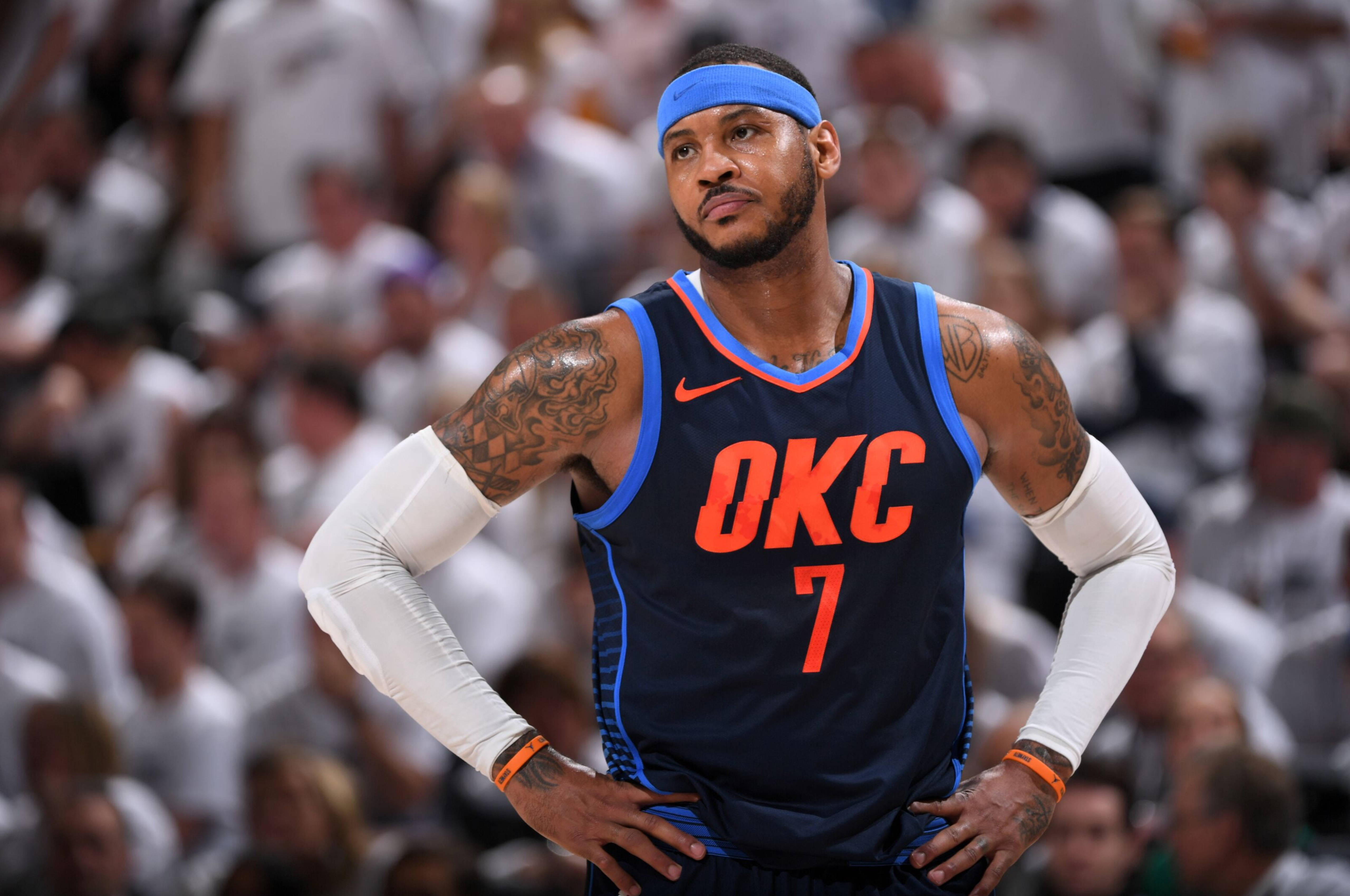 Carmelo 桌布 壁紙 — 身穿OKC球衣的職業籃球運動員在比賽中雙手叉腰站立，背後是模糊的人群。