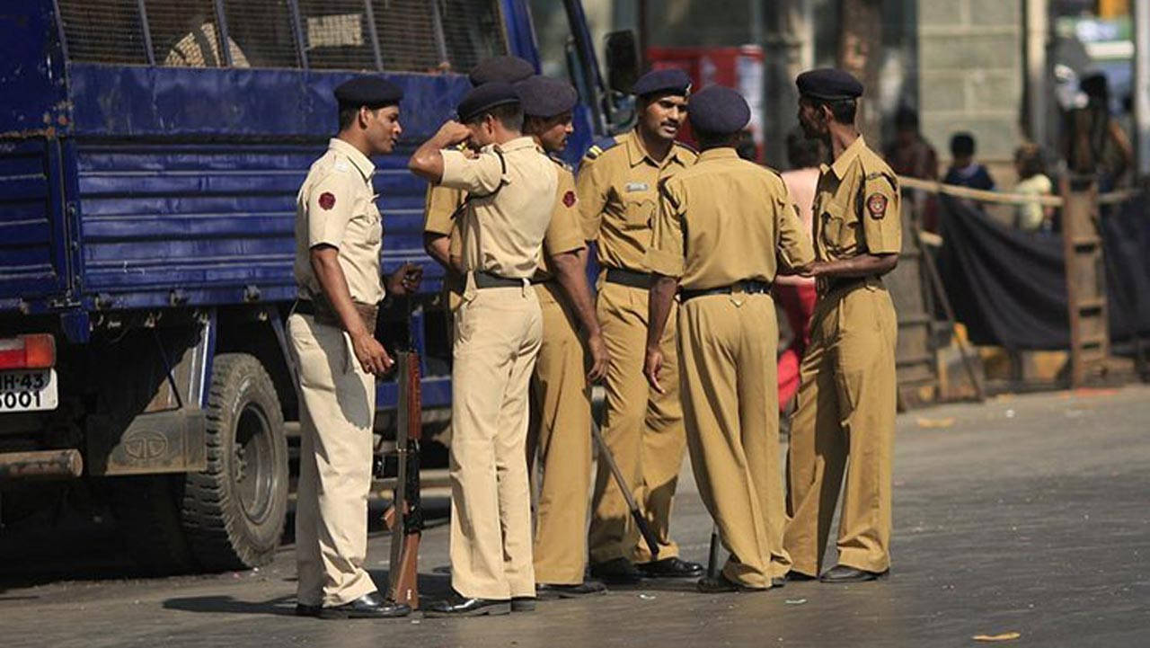 Indian 桌布 壁紙 — 身穿制服的警察站在陽光明媚的街道上，旁邊有一輛藍色卡車，其中一人正在敬禮。