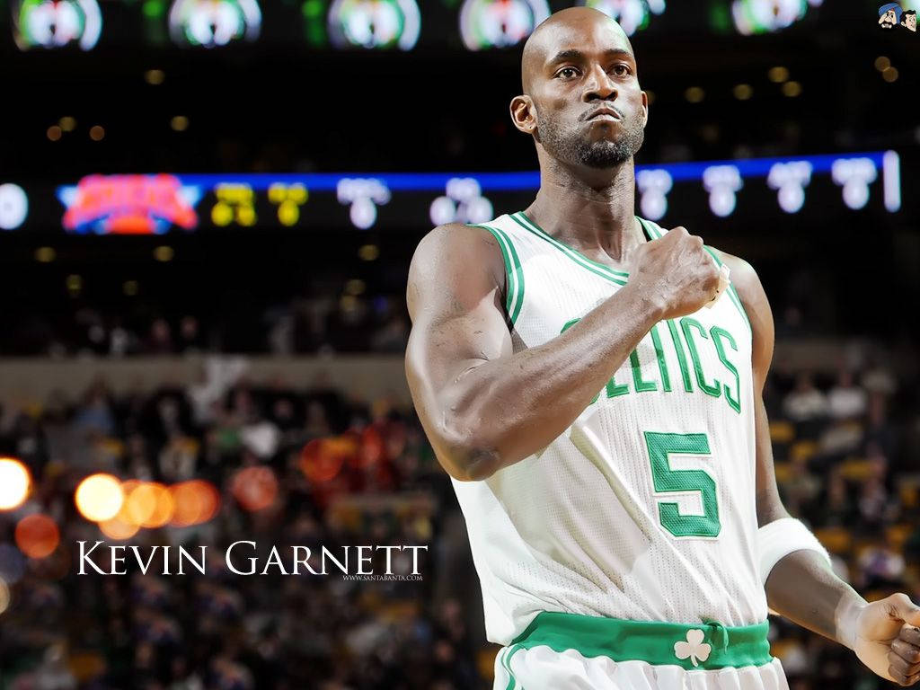 Kevin Garnett 桌布 壁紙 — 身穿塞爾提克球衣的凱文·賈奈特在比賽中於場館燈光下握緊拳頭，背後是模糊的人群。