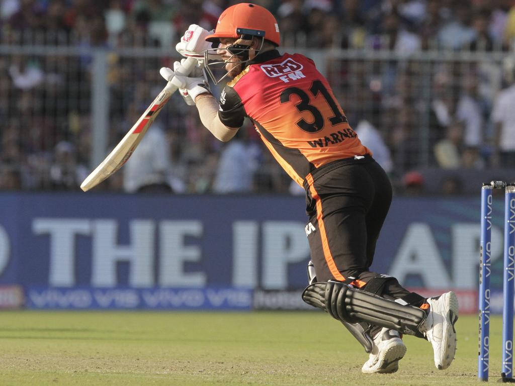 Sunrisers Hyderabad 桌布 壁紙 — 身穿橙色和黑色制服的板球運動員在日間比賽中強力揮棒，背景有觀眾。