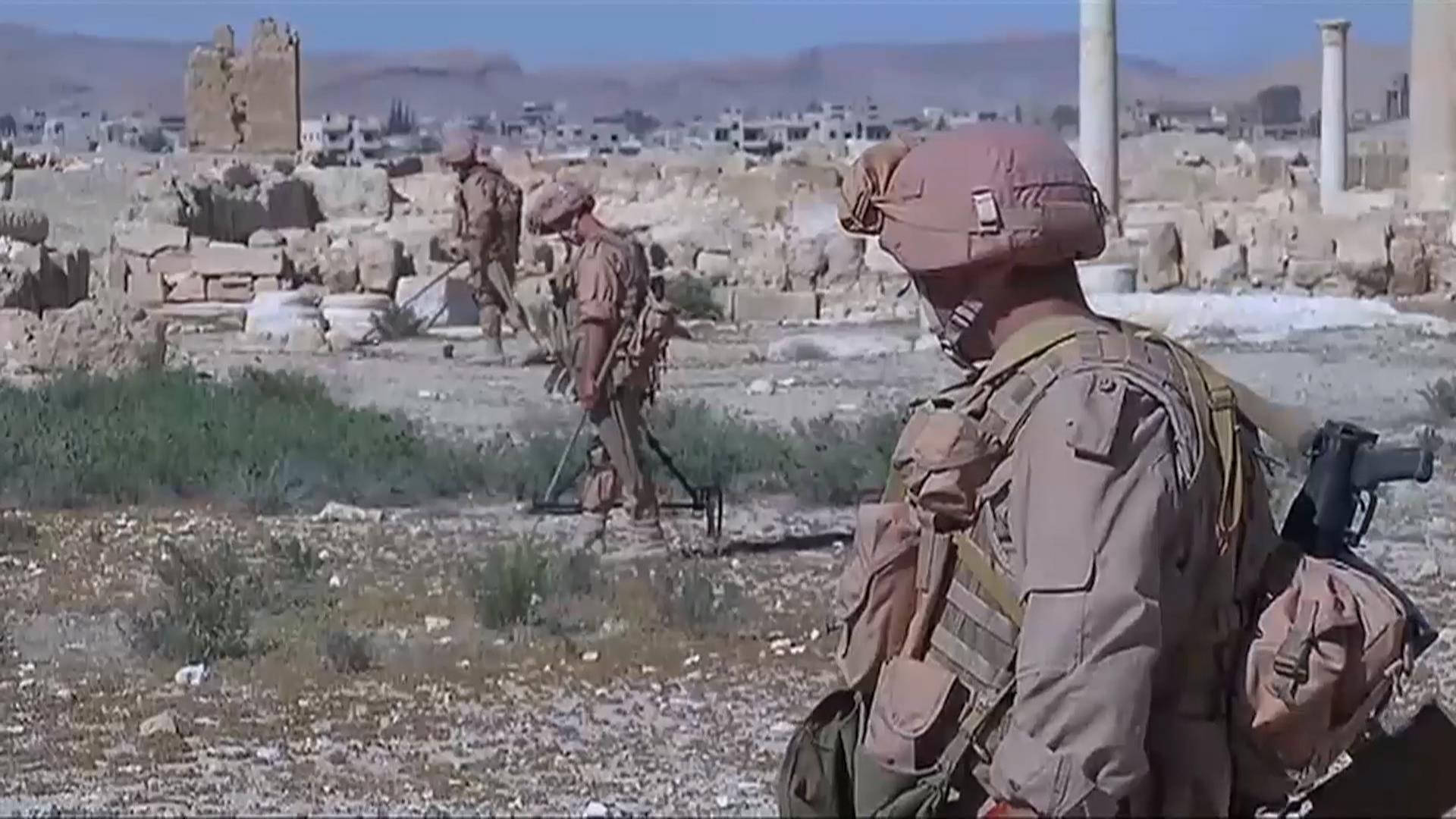 Syria 桌布 壁紙 — 身穿沙漠迷彩的士兵在明亮的日光下謹慎地穿越戰火摧殘的城市廢墟。