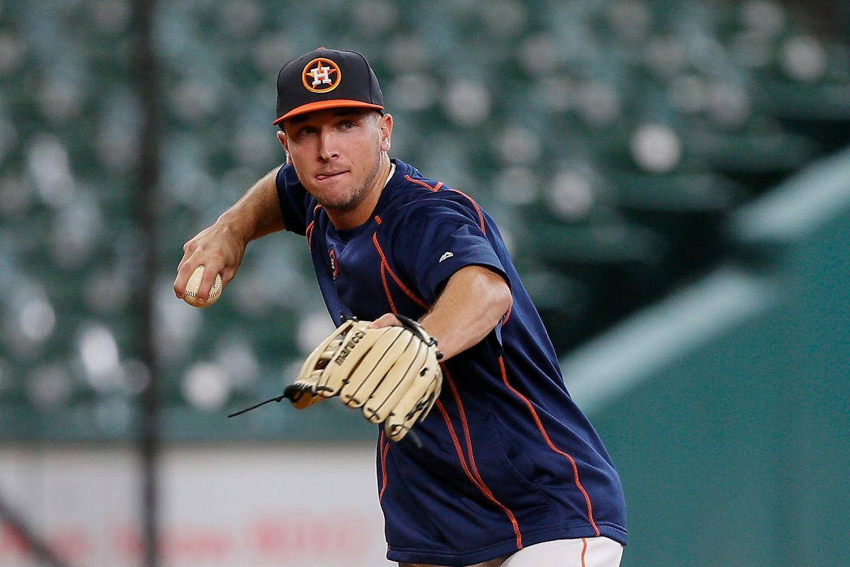 Bregman 桌布 壁紙 — 身穿海軍藍球衣的棒球投手，在模糊的球場座位背景下，專注表情投球中。
