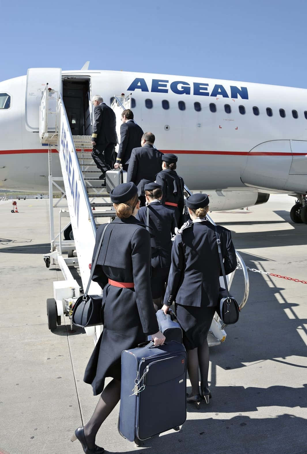 Aircraft 桌布 壁紙 — 身穿深色制服的機組人員在明亮的日光下從愛琴海航空飛機的移動樓梯下來。