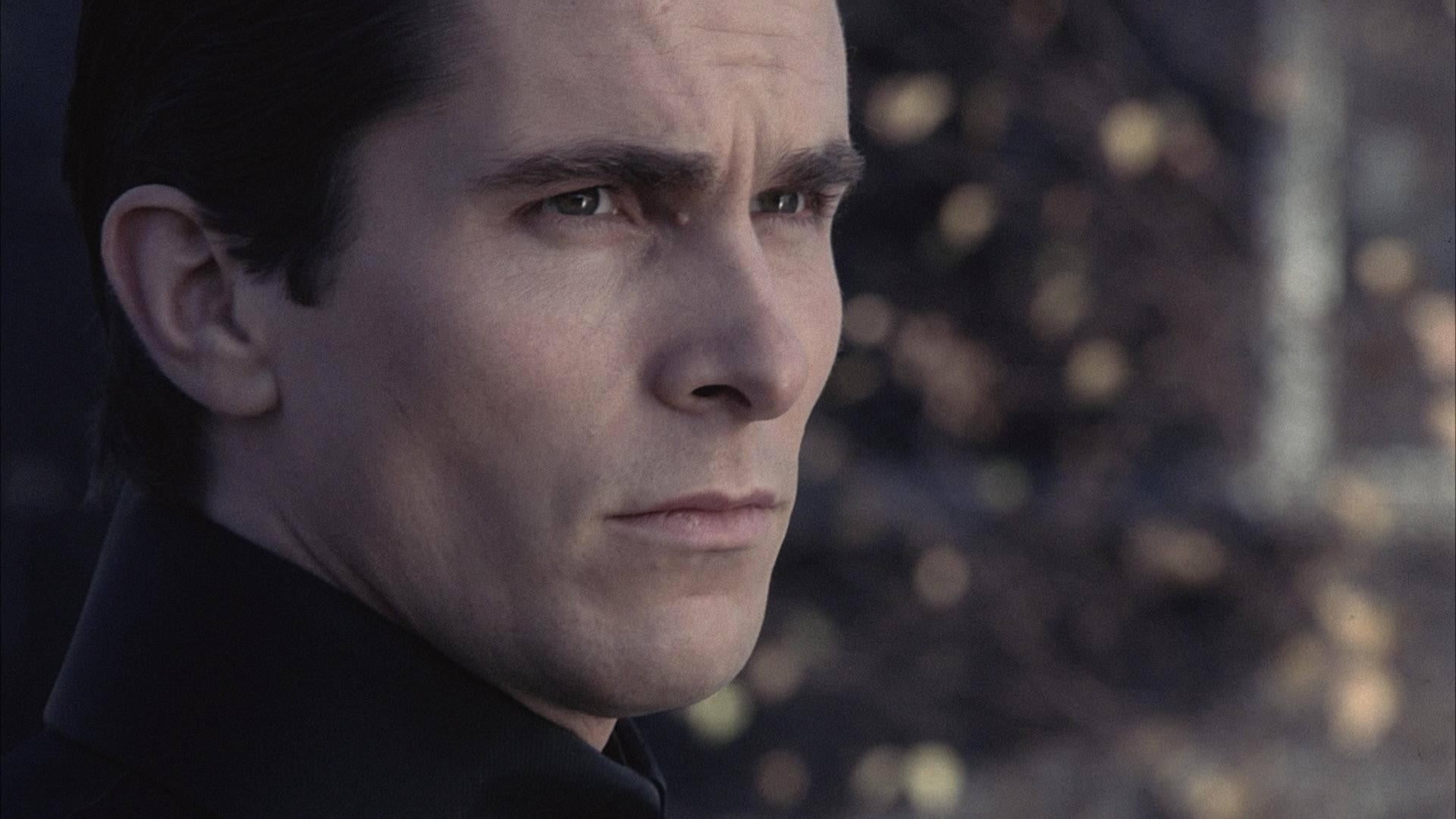 Christian Bale 桌布 壁紙 — 身穿深色衣服的男士特寫肖像，在模糊的秋日背景下若有所思地凝視。