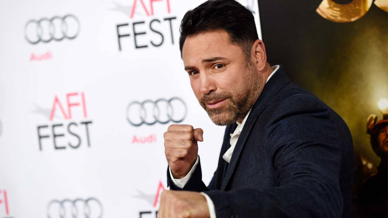 Boxing 桌布 壁紙 — 身穿深色西裝的男子在AFI FEST活動背景下自信地握拳擺姿勢。
