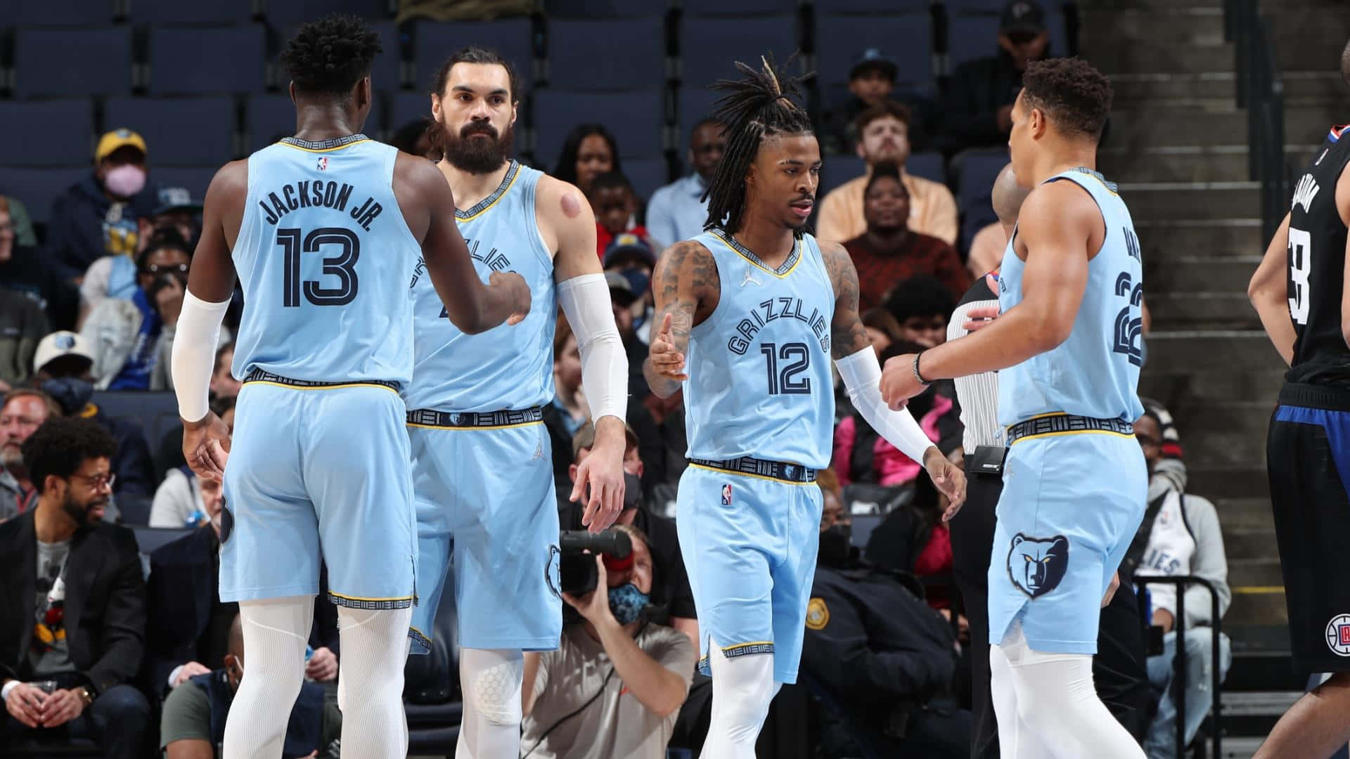 Memphis Grizzlies 桌布 壁紙 — 身穿淺藍色球衣的灰熊籃球球員在比賽期間於擁擠的球場上一起慶祝。