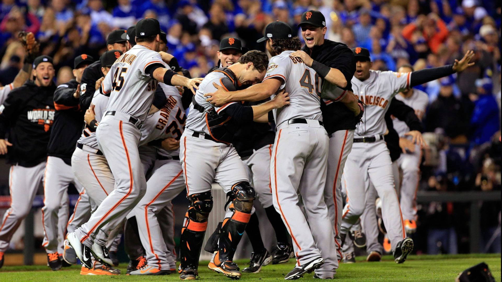 Giants 桌布 壁紙 — 身穿灰色球衣的棒球運動員在球場燈光下，於綠色場地上緊密圍成一圈慶祝勝利。