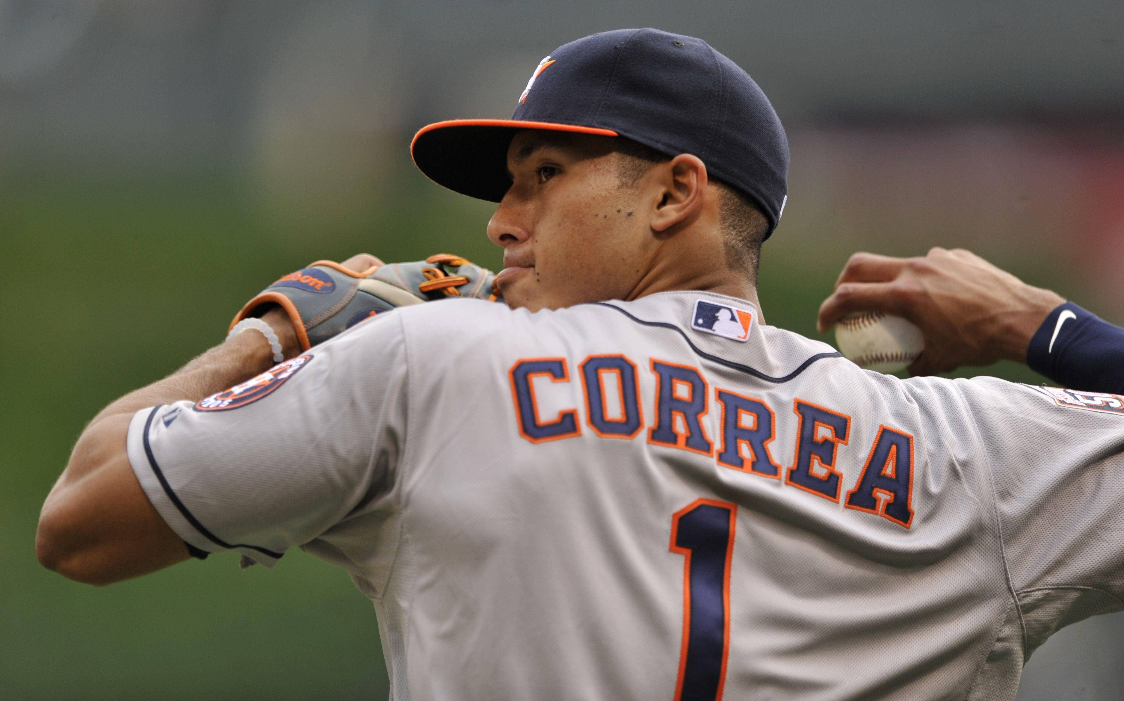 Carlos Correa 桌布 壁紙 — 身穿灰色球衣的棒球選手 Correa 在模糊的球場背景下，專注地準備投球。