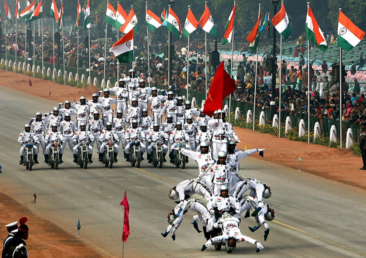 Republic Day 桌布 壁紙 — 身穿白色制服的機車騎士在背景中飄揚的印度國旗襯托下，表演同步特技隊形。