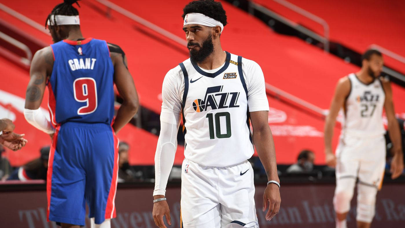 mike conley 桌布 壁紙 — 身穿白色和藍色球衣的籃球運動員離開球場，身後是紅色的體育場座位。