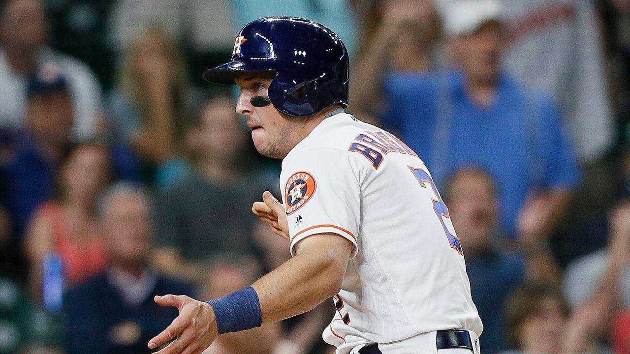 Bregman 桌布 壁紙 — 身穿白色球衣和藍色頭盔的棒球運動員在體育場燈光下的夜間比賽中激烈地做手勢。