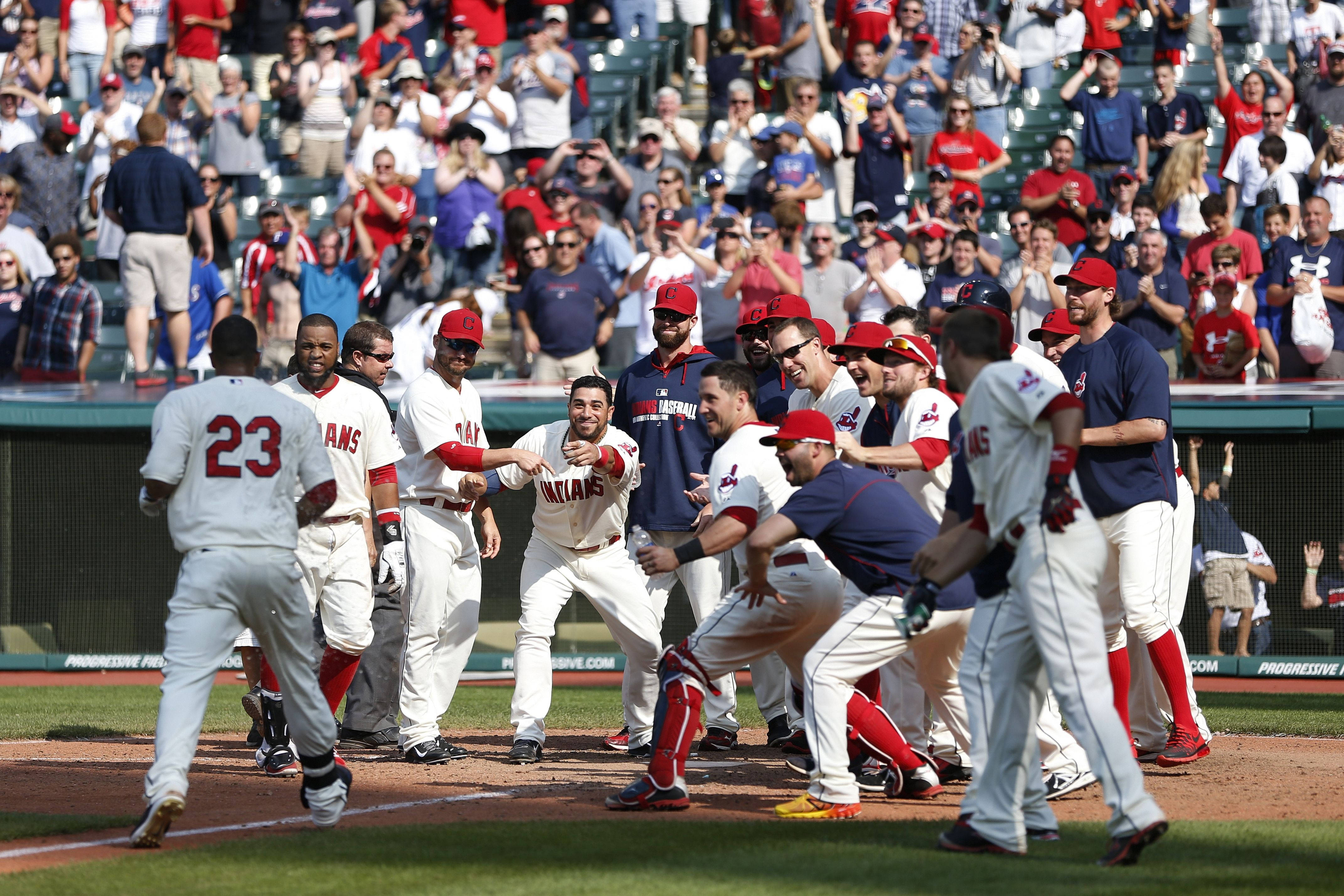 Cleveland Indians 桌布 壁紙 — 身穿白色球衣的棒球運動員在擠滿觀眾的球場上，在明亮的日光下慶祝全壘打。