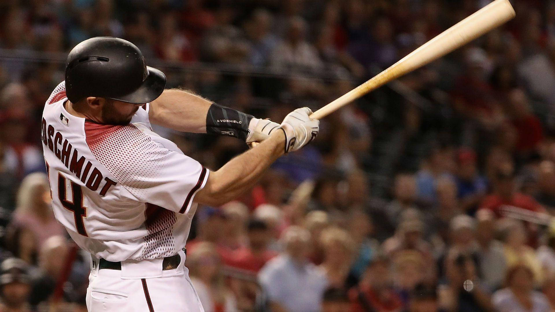 Paul Goldschmidt 桌布 壁紙 — 身穿白色球衣的棒球選手 Josh Schmidt 在揮棒中，背景有模糊的人群。