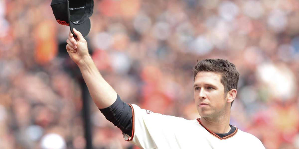 Posey 桌布 壁紙 — 身穿白色球衣的棒球選手在日間比賽中向人群舉起黑色帽子。