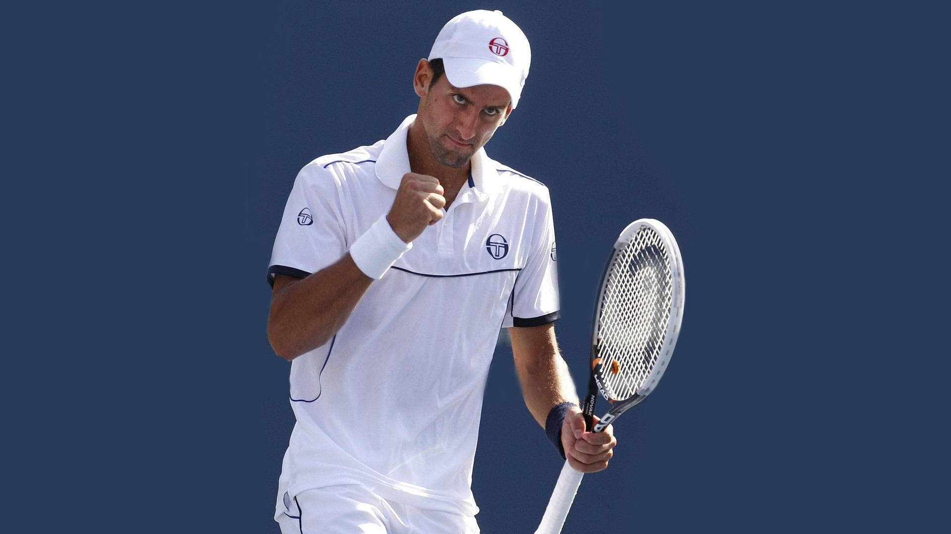 Novak 桌布 壁紙 — 身穿白色裝備的網球運動員在純藍色背景下高舉拳頭，勝利地握著球拍。