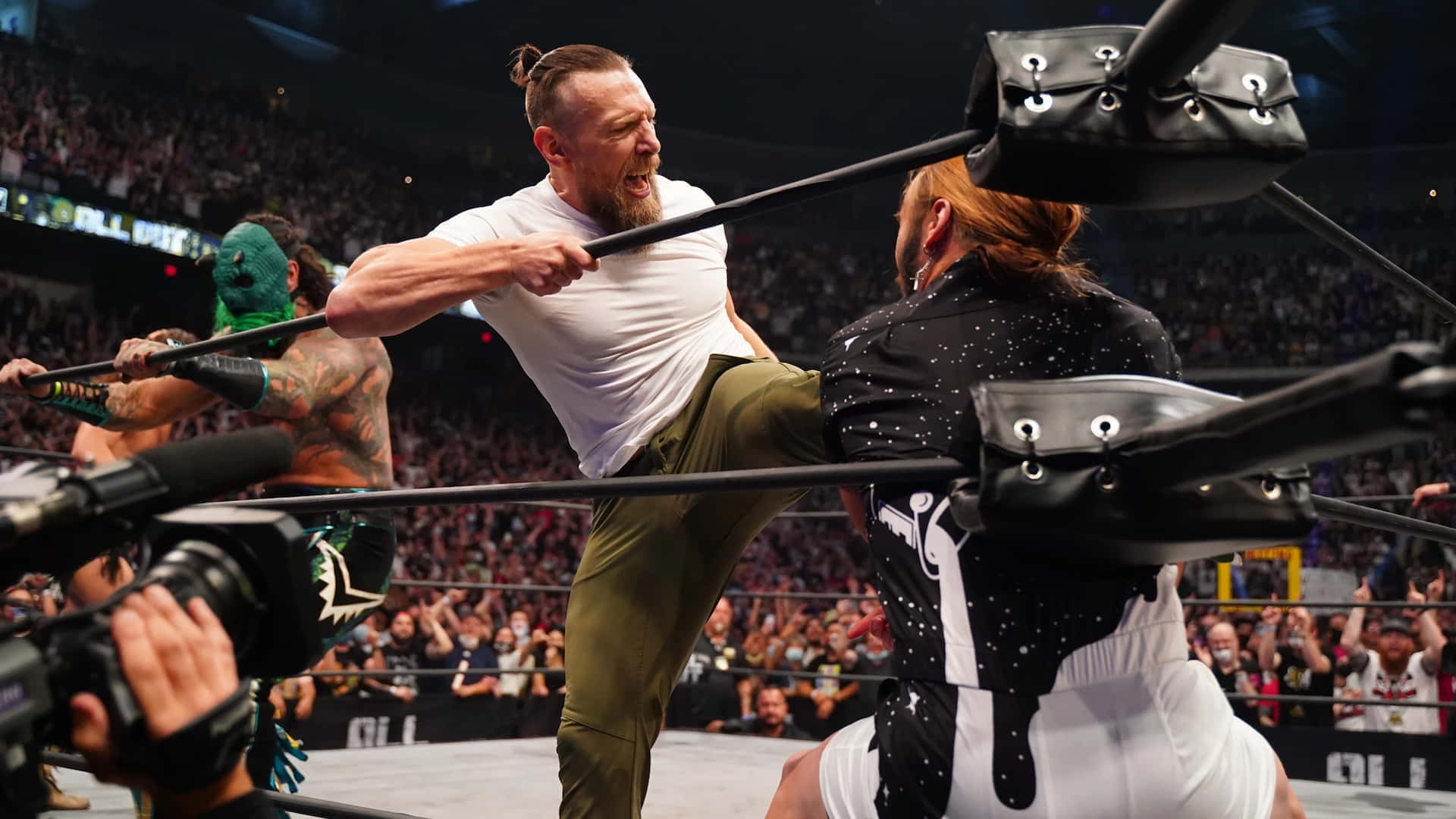 Aew 桌布 壁紙 — 身穿白色襯衫的摔角手在摔角場內向身穿黑色外套的對手踢出高踢，觀眾歡呼。