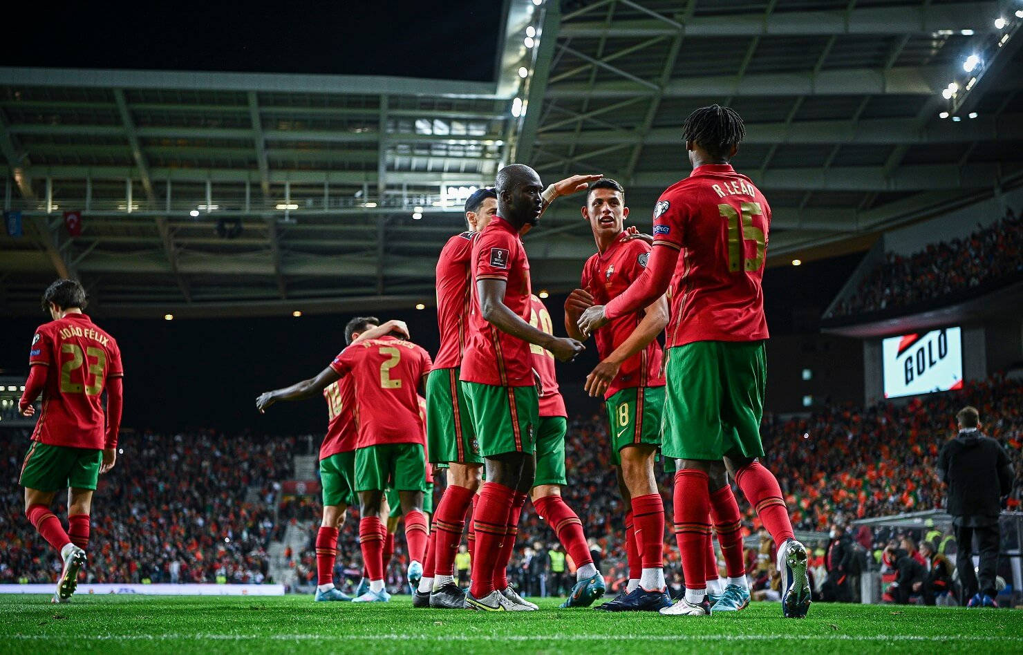 Portugal 桌布 壁紙 — 身穿紅綠球衣的葡萄牙足球員在夜間燈光明亮的球場上慶祝進球。