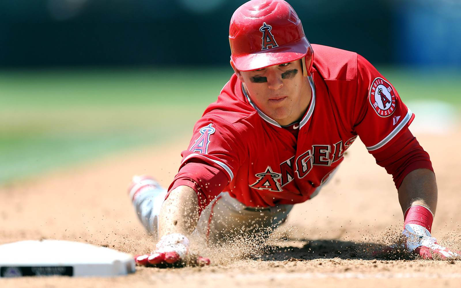 Mike Trout 桌布 壁紙 — 身穿紅色天使隊球衣的棒球選手在日間比賽中頭部滑壘進壘，揚起泥土。