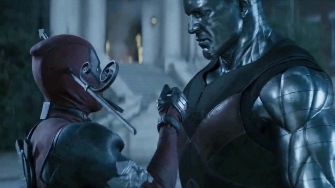 Deadpool And Colossus 桌布 壁紙 — 身穿紅色戰衣的死侍在夜晚昏暗的城市小巷中與一名金屬裝甲男子對峙。