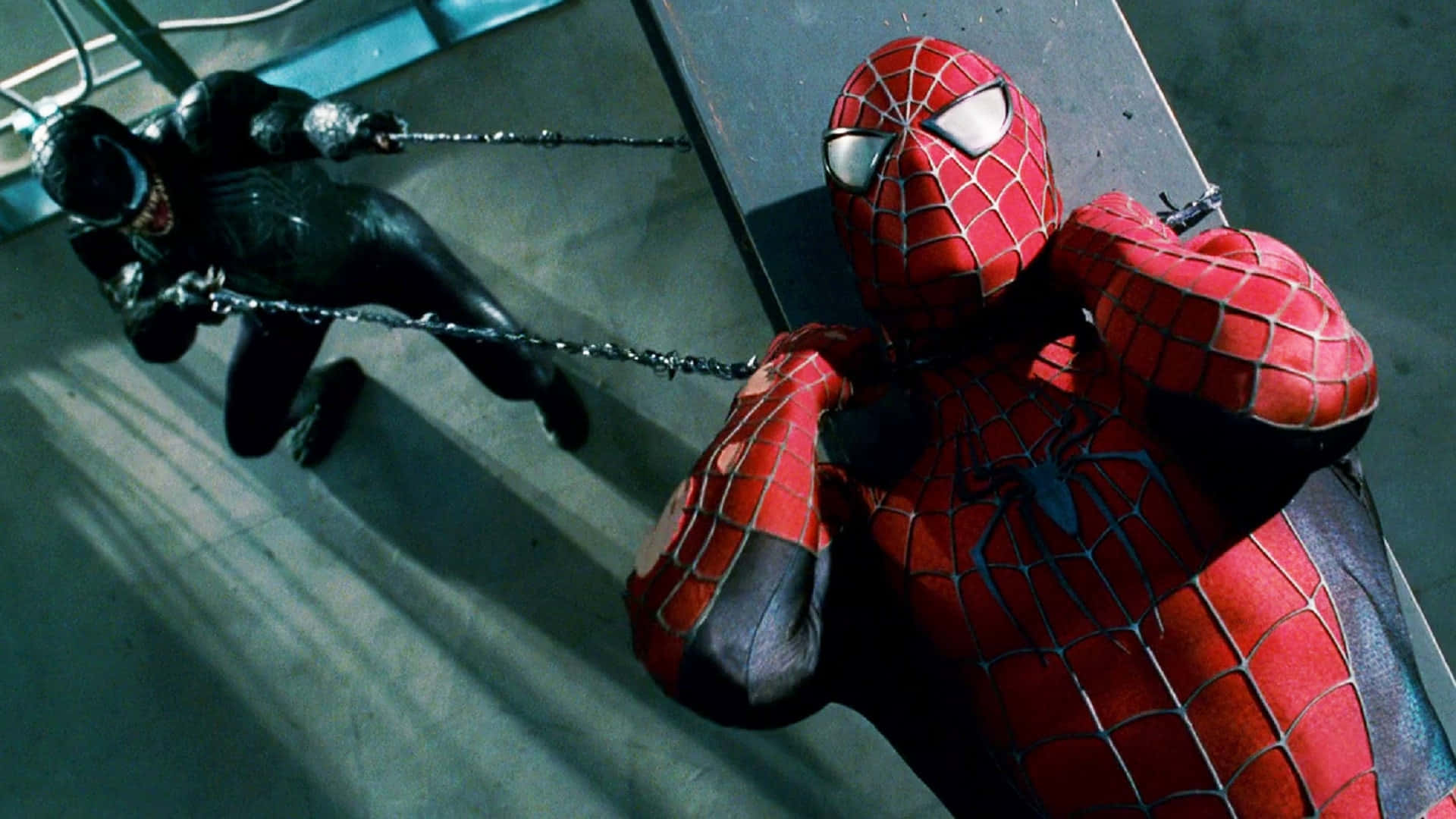 Spider Man 3 桌布 壁紙 — 身穿紅色戰衣的蜘蛛人在金屬屋頂上，在戲劇性的燈光下與身穿黑色戰衣的猛毒搏鬥。