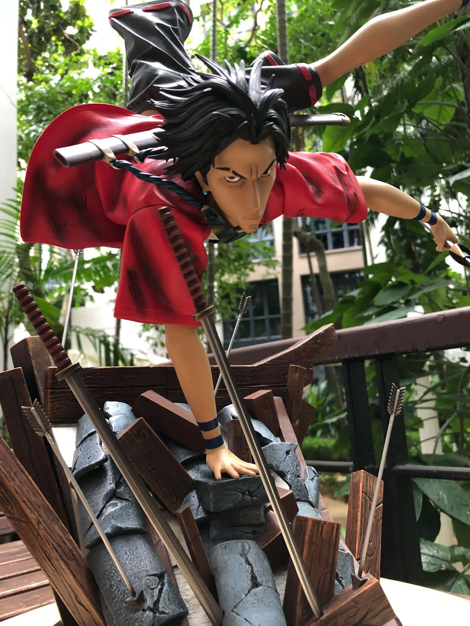Samurai Champloo 桌布 壁紙 — 身穿紅色斗篷的劍士在茂密綠葉中動態跳躍的動漫人偶。