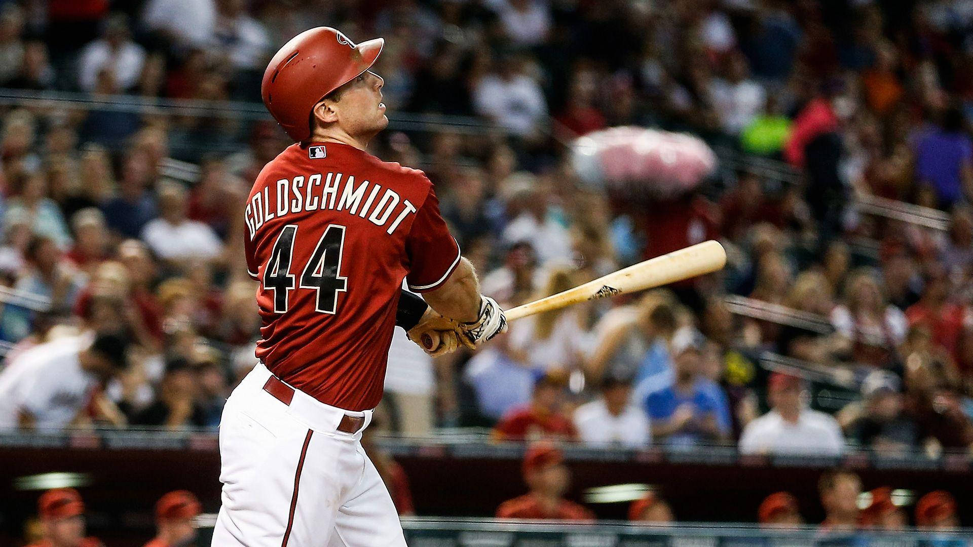 Paul Goldschmidt 桌布 壁紙 — 身穿紅色球衣的Goldschmidt在日間比賽中揮棒，背景是模糊的人群。