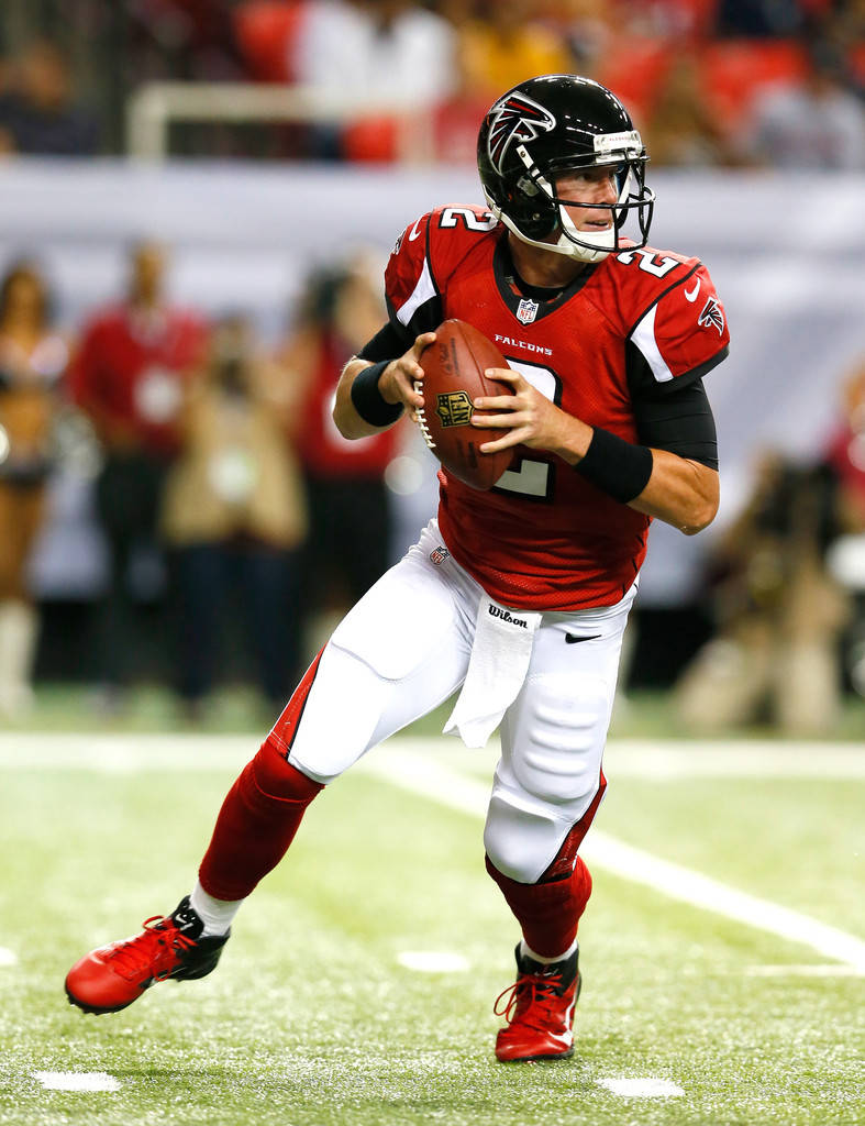 Matt Ryan 桌布 壁紙 — 身穿紅色球衣的亞特蘭大獵鷹四分衛在夜間比賽中於球場燈光下準備擲出橄欖球。