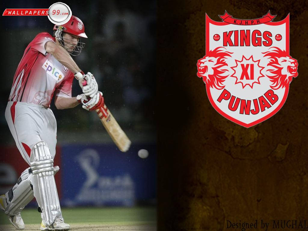 punjab kings 桌布 壁紙 — 身穿紅色球衣的板球運動員在球場燈光下，於Kings XI Punjab標誌旁揮棒擊球。