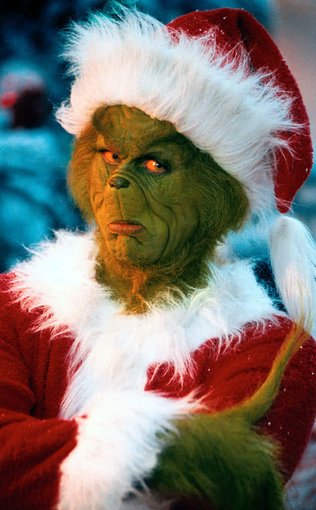 Santa Claus 桌布 壁紙 — 身穿紅色聖誕老人套裝（附白色毛邊和帽子）的鬼靈精，在白雪皚皚的冬季背景下怒目而視。