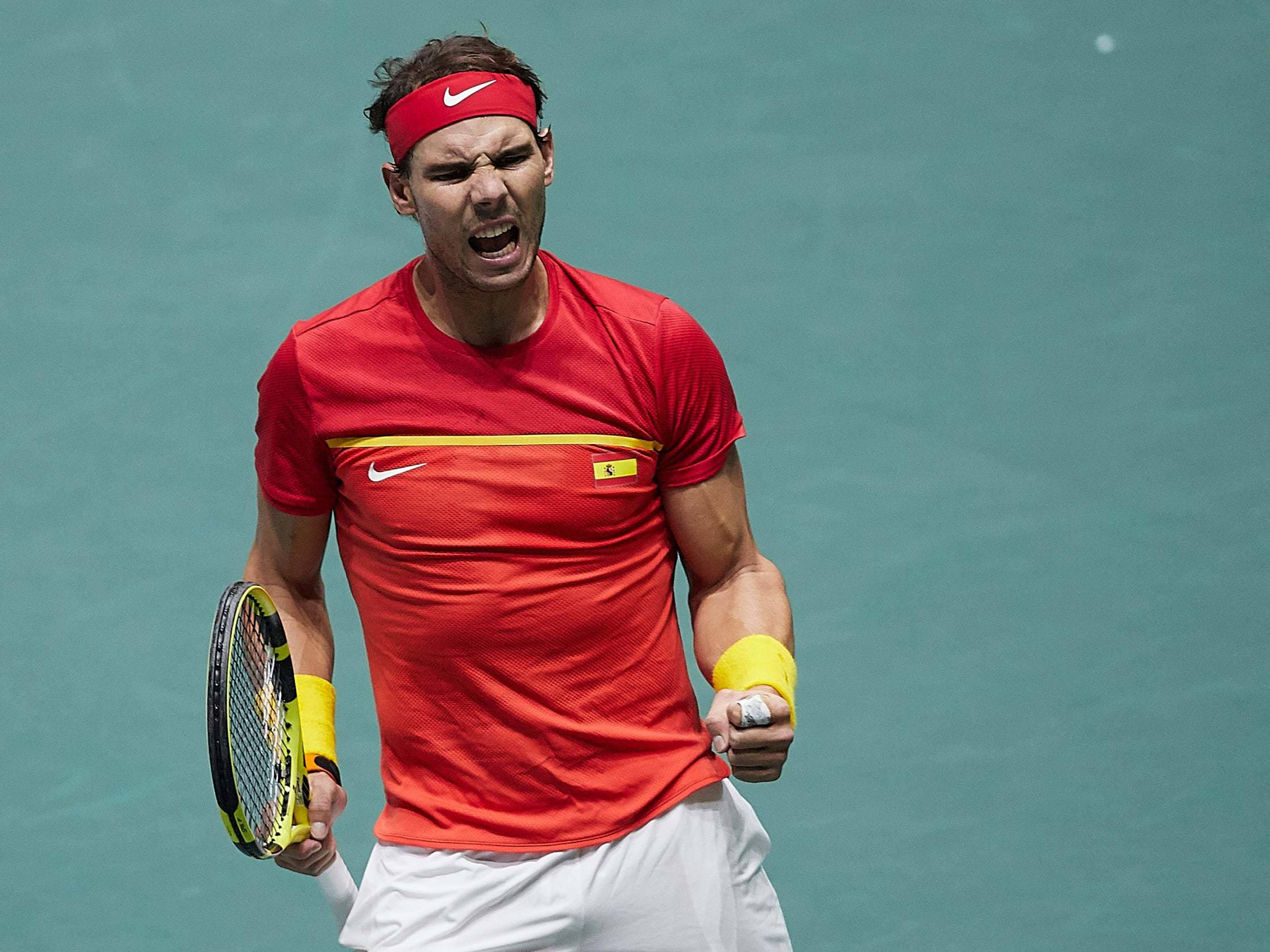 Rafael 桌布 壁紙 — 身穿紅色襯衫和頭帶的網球選手在青綠色球場上握緊拳頭、揮舞球拍怒吼。
