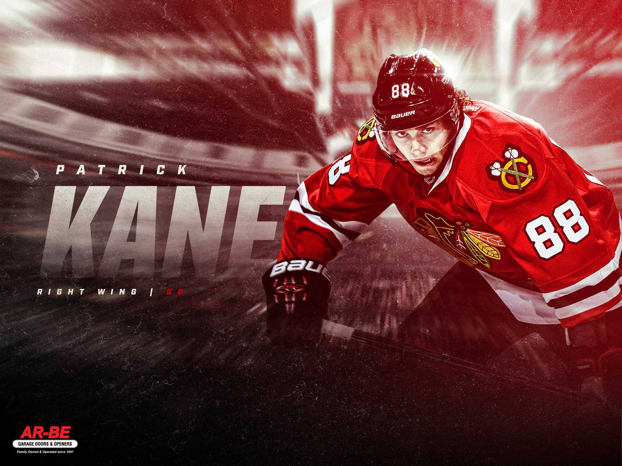 Blackhawks 桌布 壁紙 — 身穿紅色黑鷹隊88號球衣的Patrick Kane在戲劇性的紅光下，於冰球比賽中帶著強烈的專注力向前猛衝。