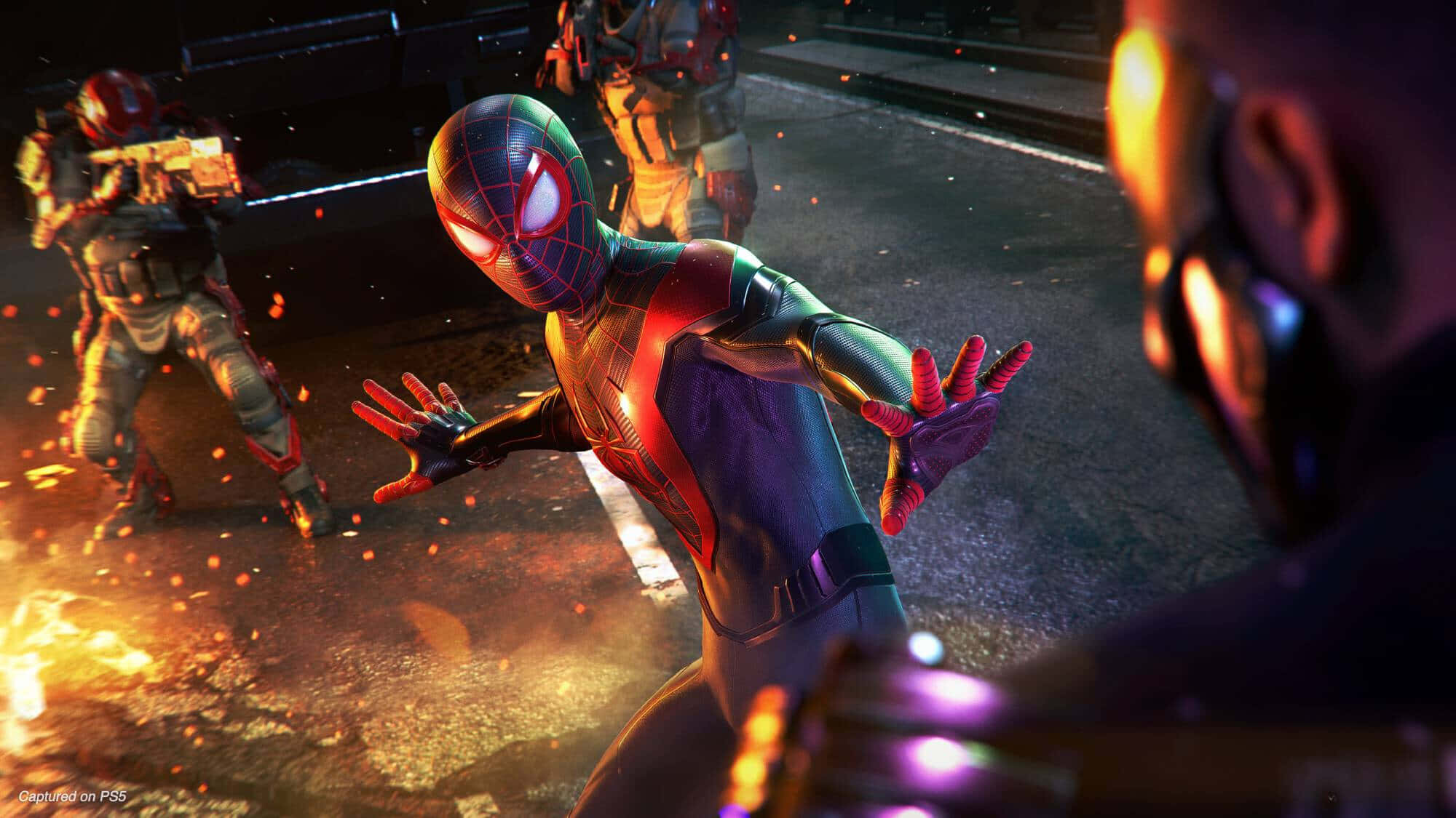 Ps5 Games 桌布 壁紙 — 身穿紅藍戰衣的蜘蛛人在武裝敵人和發光碎片中，躍過燃燒的都市街道。
