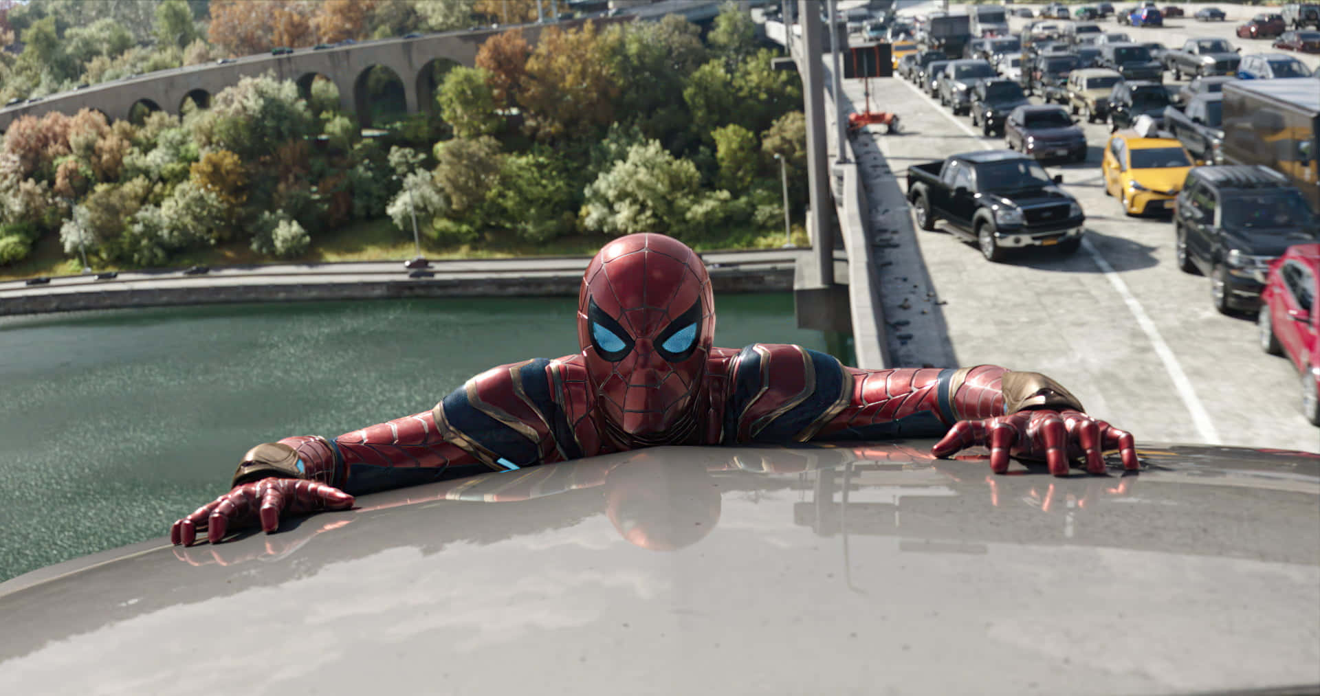 Spider Man No Way Home 桌布 壁紙 — 身穿紅金戰甲的蜘蛛人靠在高架橋上，俯瞰車流與綠地。