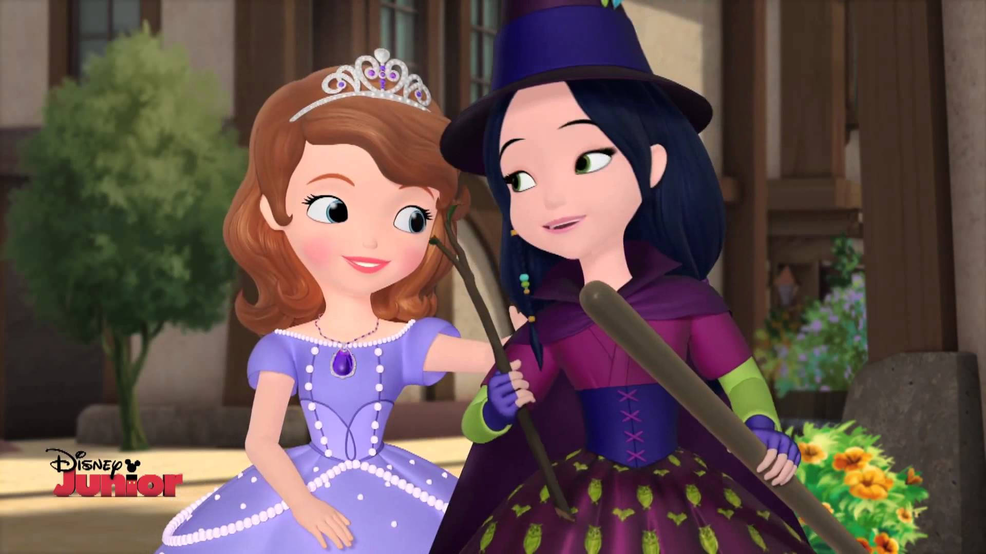 Princess 桌布 壁紙 — 身穿紫色長裙的蘇菲亞公主在陽光明媚的庭院裡微笑，旁邊是一位戴著紫色帽子、拿著掃帚的女巫。