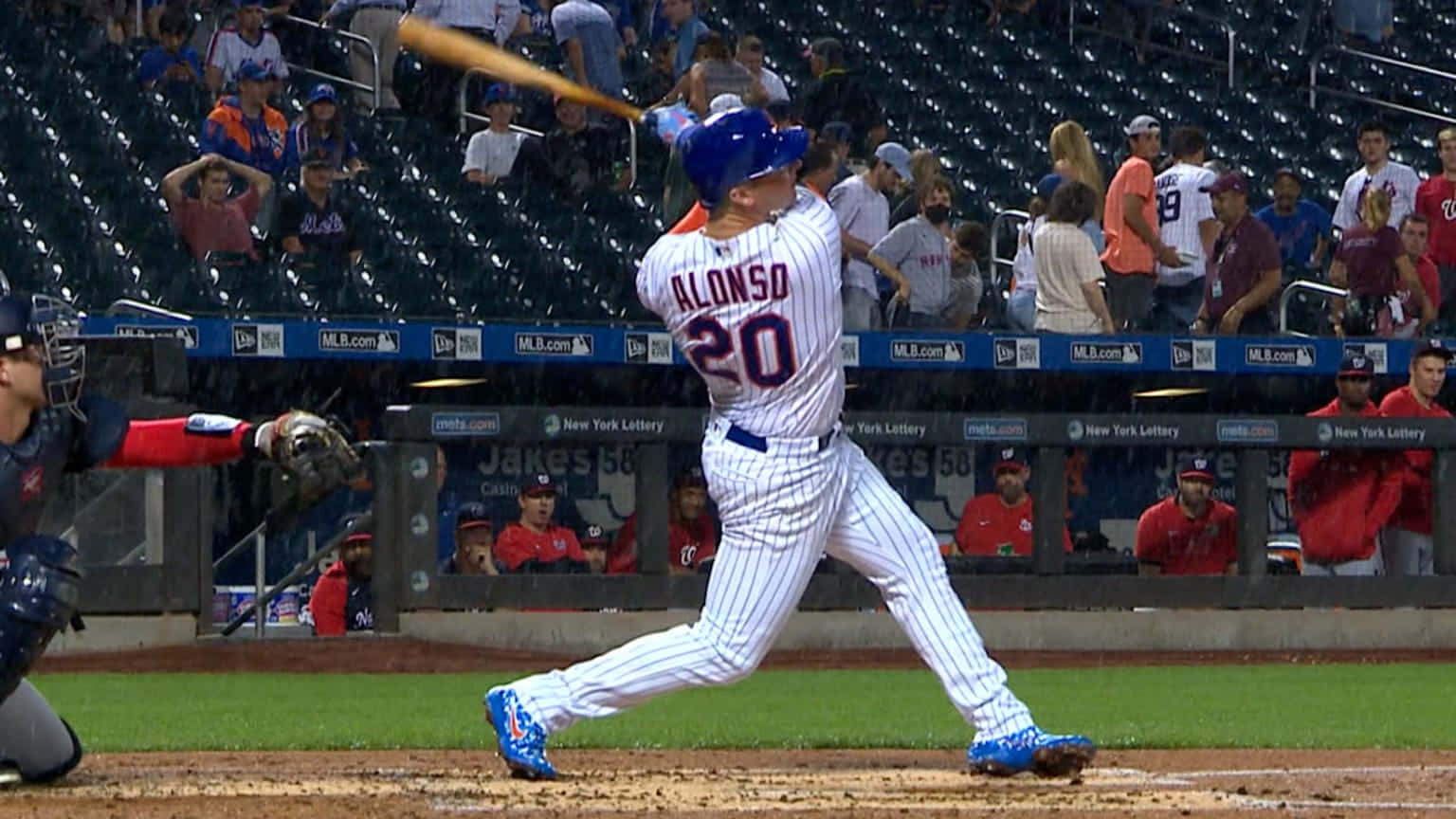 Pete Alonso 桌布 壁紙 — 身穿細條紋球衣的棒球選手Alonso在球場上揮棒，觀眾在觀看。
