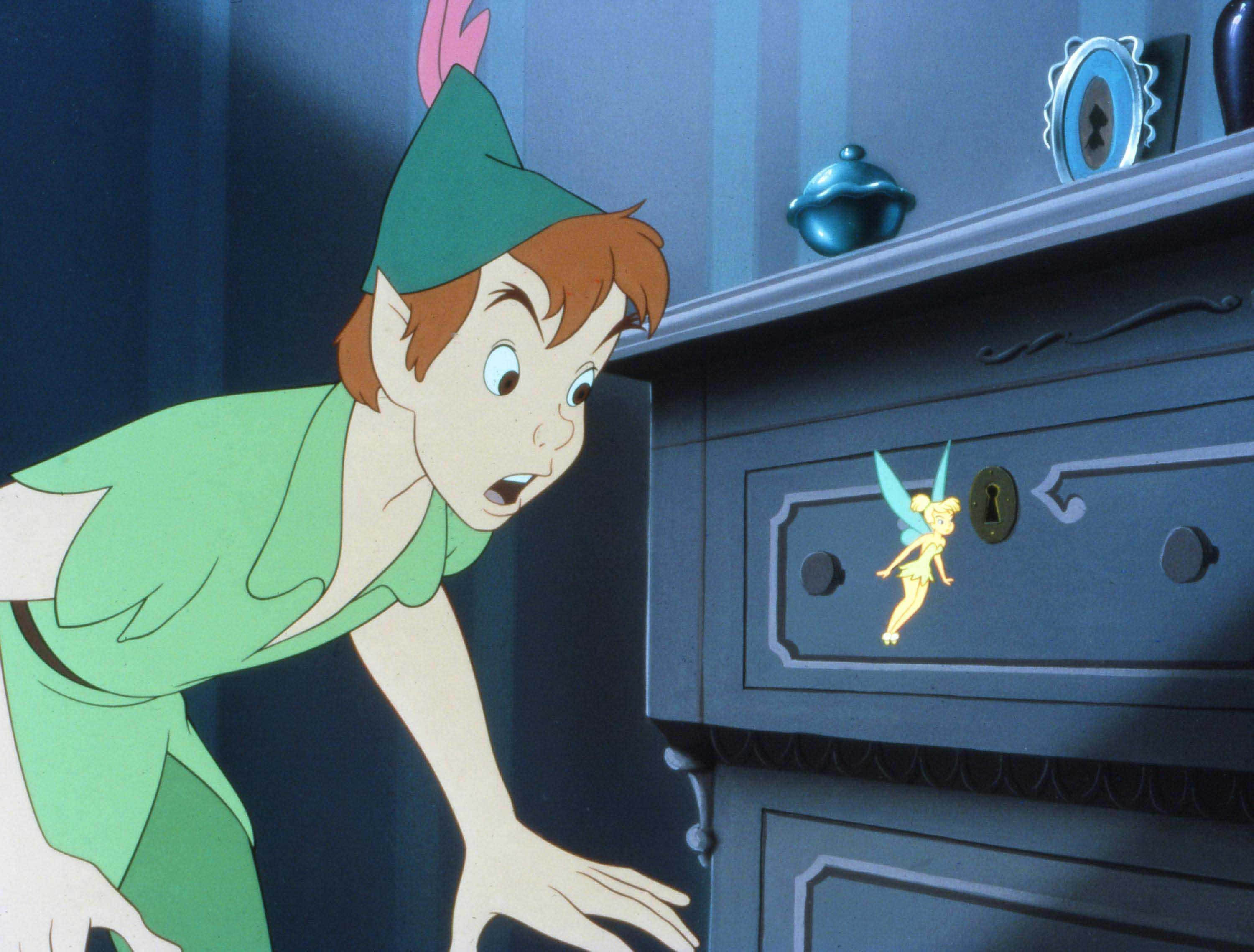 Peter Pan 桌布 壁紙 — 身穿綠色服裝的小飛俠彼得潘驚訝地看著在深藍色抽屜櫃上發光的小叮噹。