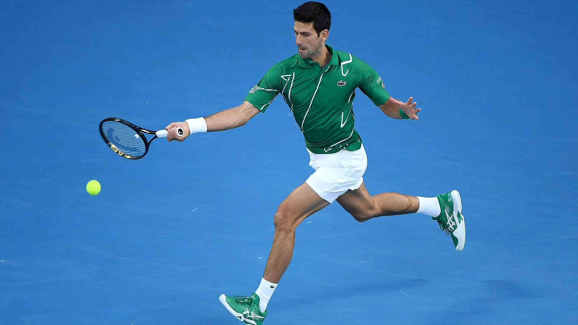 Australian Open 桌布 壁紙 — 身穿綠色球衣的網球選手向前撲出，在充滿活力的藍色球場上擊打黃色網球。