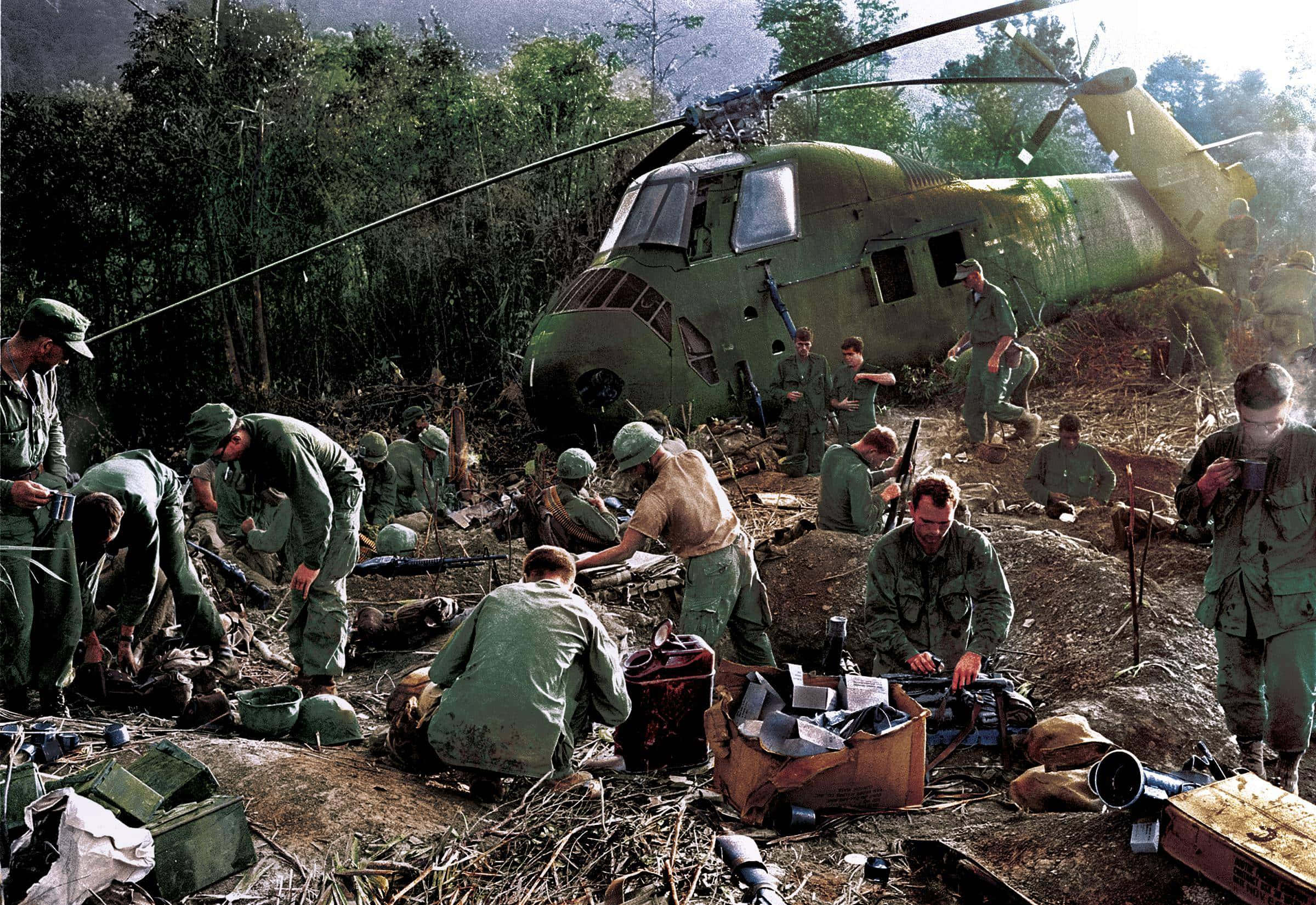 越南 桌布 壁紙 — 身穿綠色軍裝的士兵在白天聚集在茂密叢林空地上的一架墜毀軍用直升機周圍。