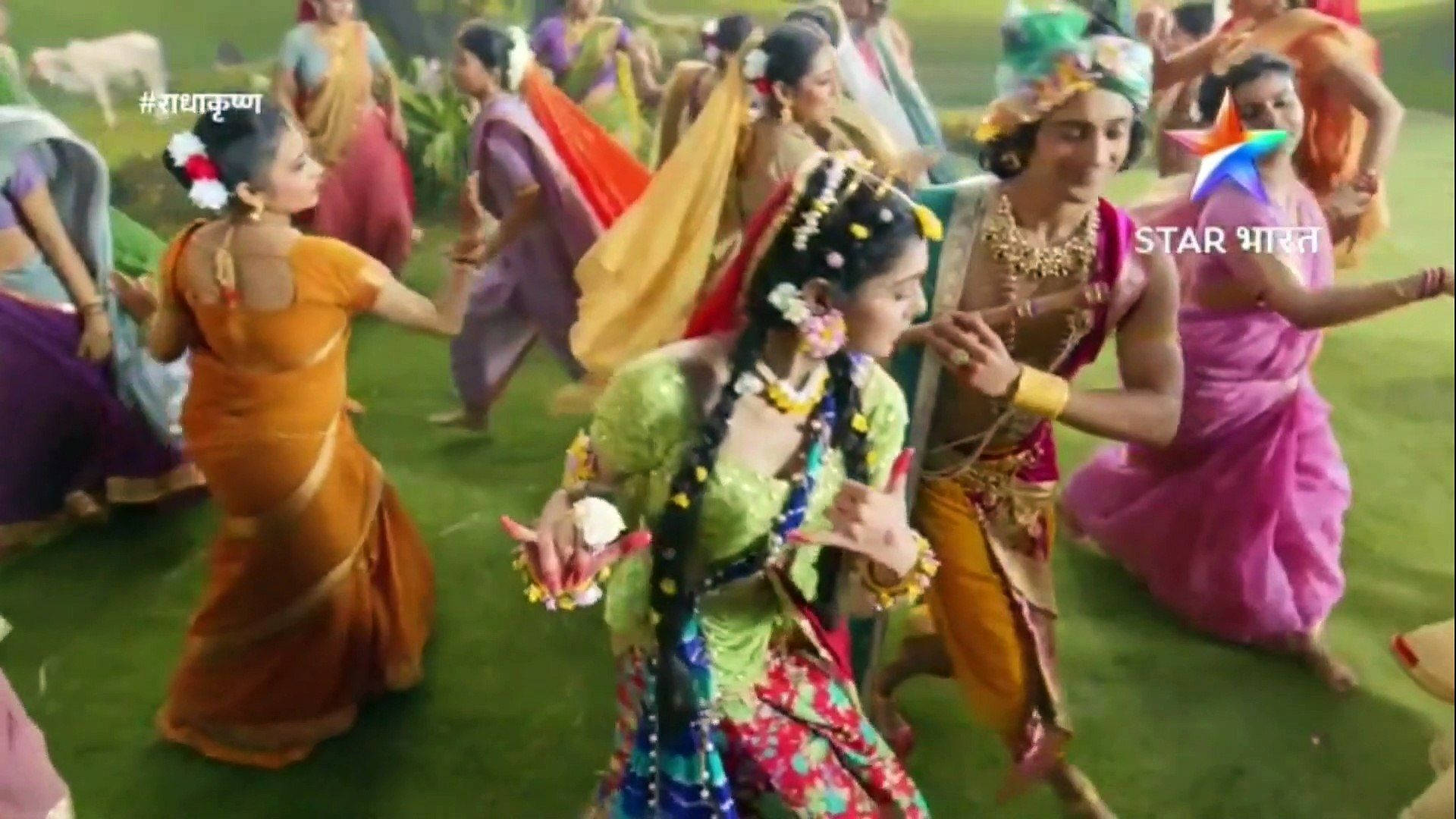 radha krishna serial 桌布 壁紙 — 身穿色彩繽紛傳統印度服飾的活力舞者，在明媚陽光下於翠綠草地上表演生動的民間舞蹈。