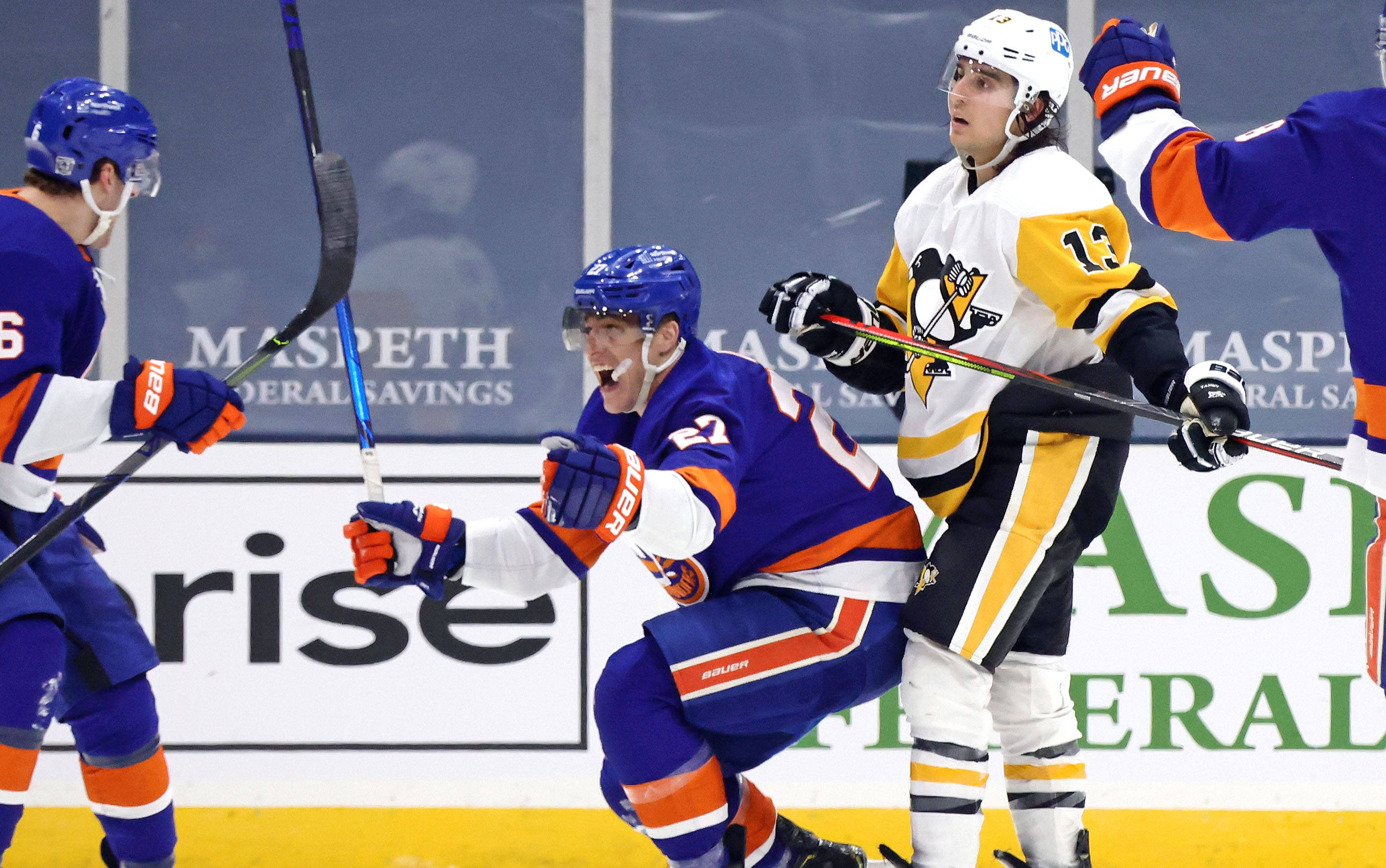 New York Islanders 桌布 壁紙 — 身穿藍橙色球衣的冰上曲棍球運動員在冰場上與隊友瘋狂慶祝，比賽氣氛激烈。