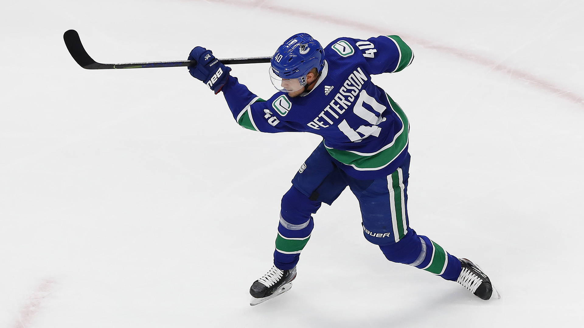 hockey 桌布 壁紙 — 身穿藍綠色球衣的冰球運動員Petterson在比賽期間持球棍在冰場上滑行。